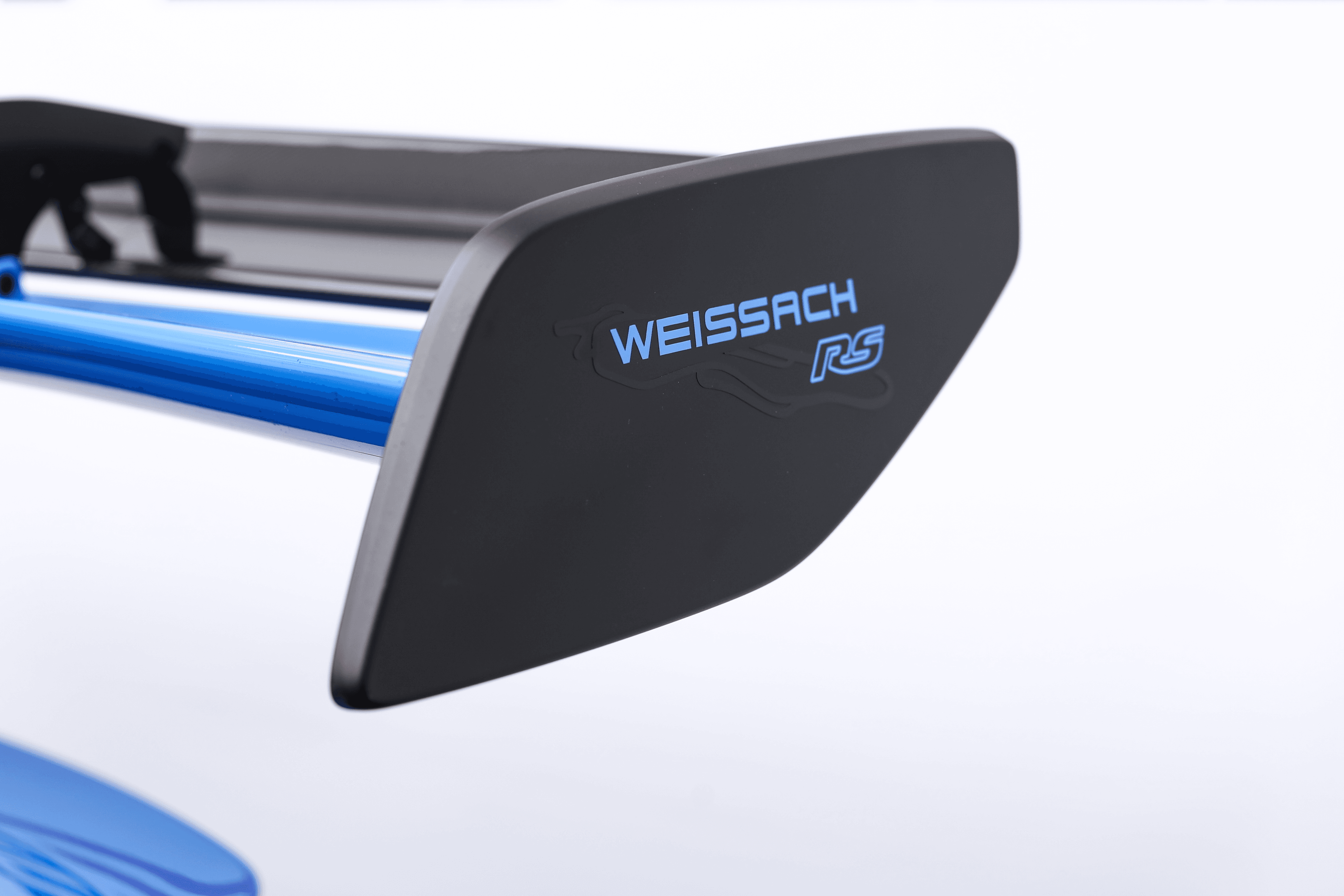 Zoom sur l'aileron arrière de la Porsche GT3RS bleue, avec le logo Weissach, symbole d'une performance et d'une précision d'ingénierie exceptionnelles.
