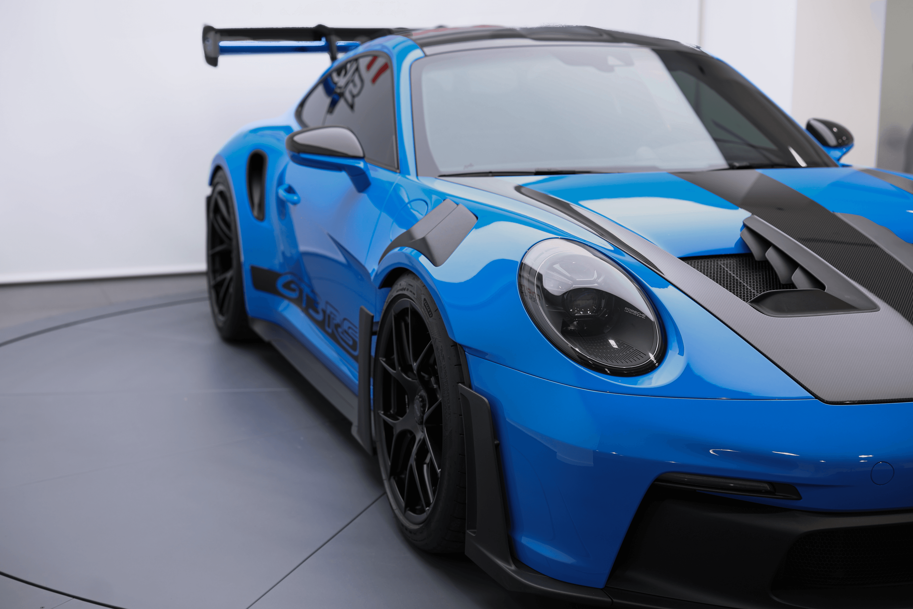 Vue dynamique de la Porsche GT3RS shark blue, mettant en avant son design agressif et ses performances optimales, une véritable icône de l'ingénierie automobile.
