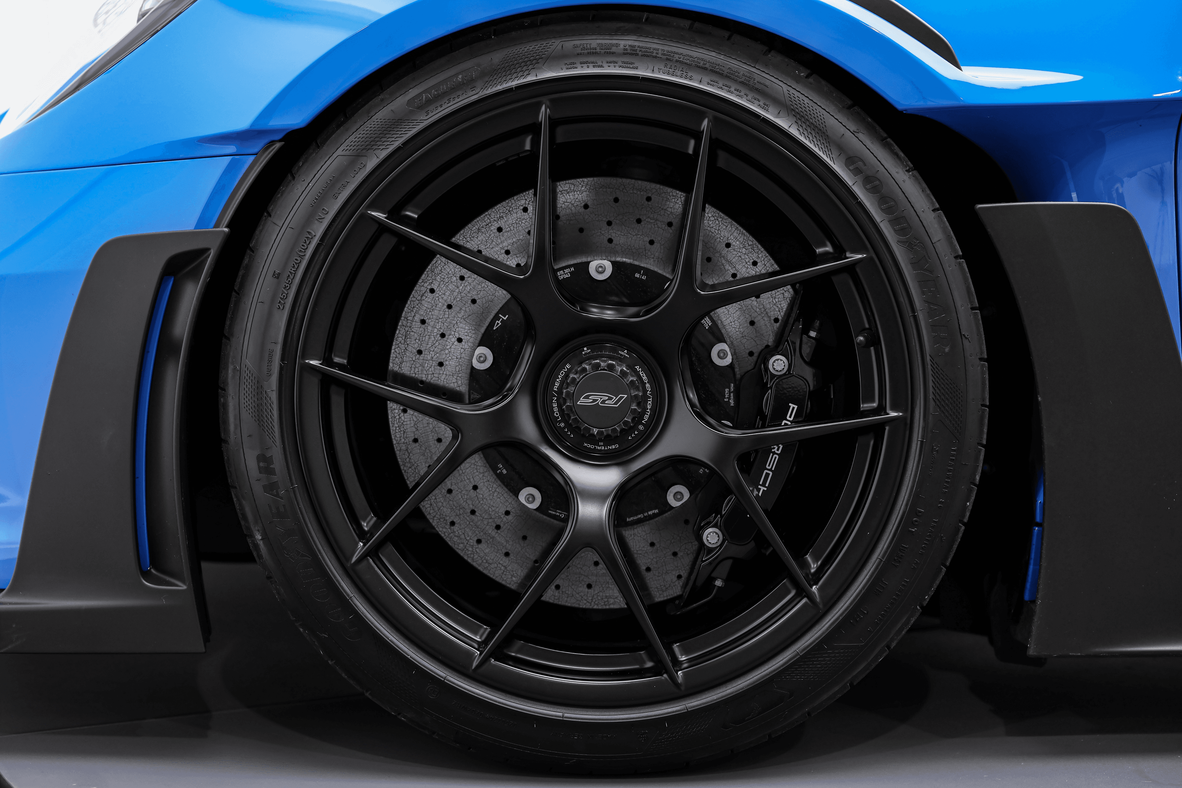 Vue rapprochée de la roue de la Porsche GT3RS Shark blue, mettant en avant les disques de frein perforés et le design aérodynamique, essentiel pour une performance de freinage optimale.