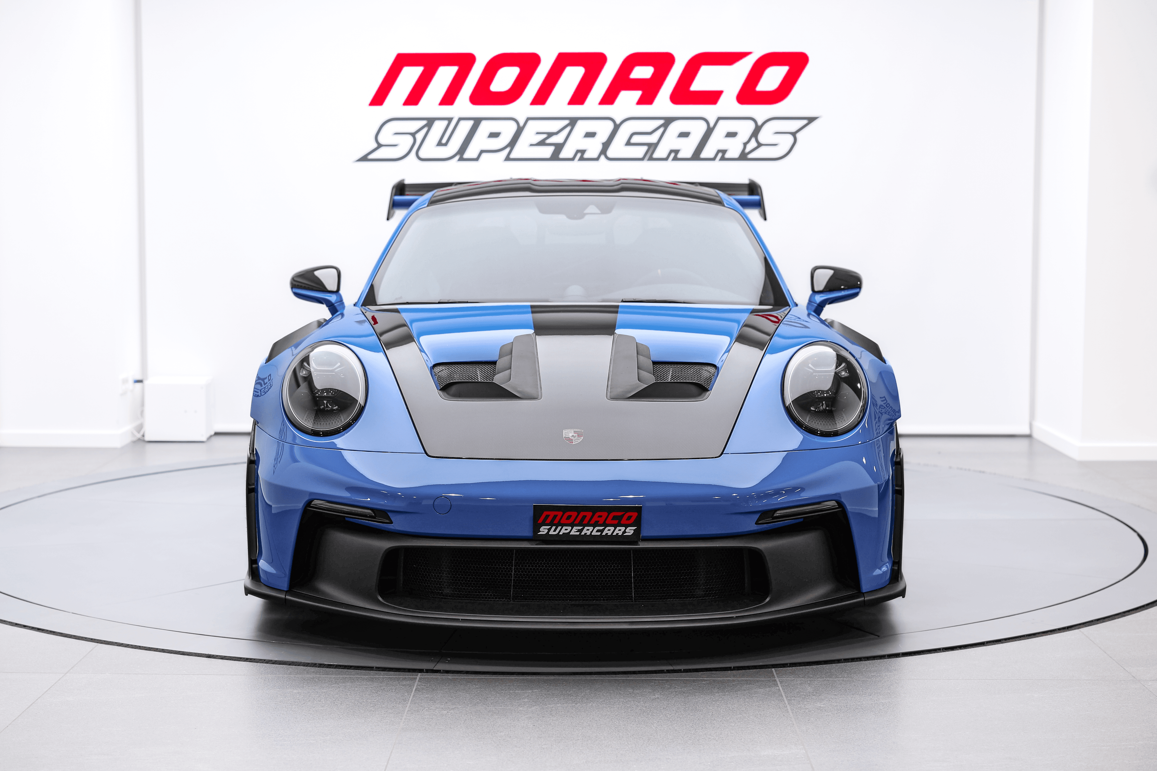 Découvrez la Porsche GT3RS shark blue de face dans notre showroom à Monaco, une supercar qui allie puissance et élégance inégalée.