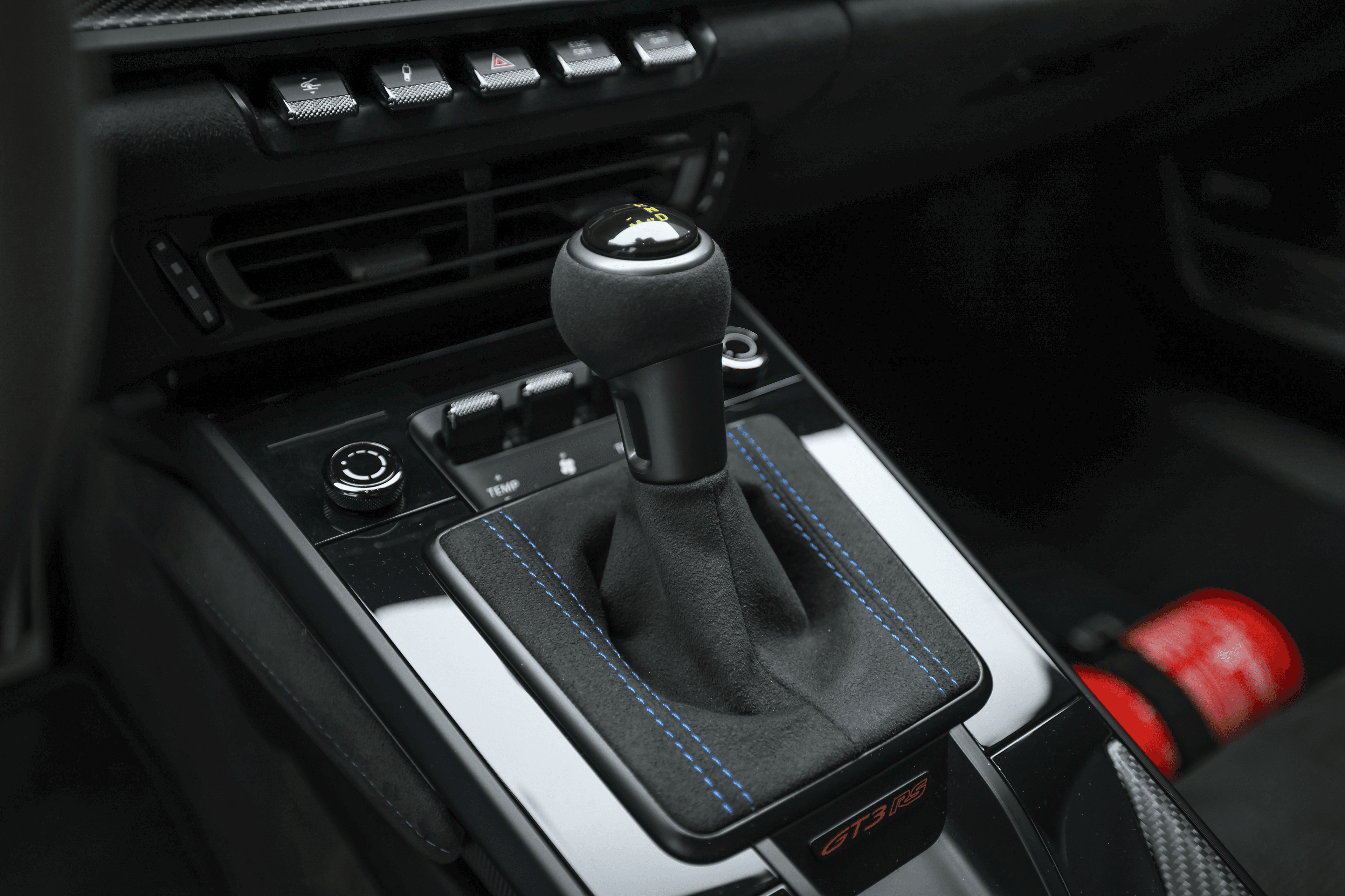 Détail du levier de vitesse de la Porsche GT3RS bleue, avec son design sportif et ses finitions en cuir, soulignant l'engagement vers une expérience de conduite immersive.