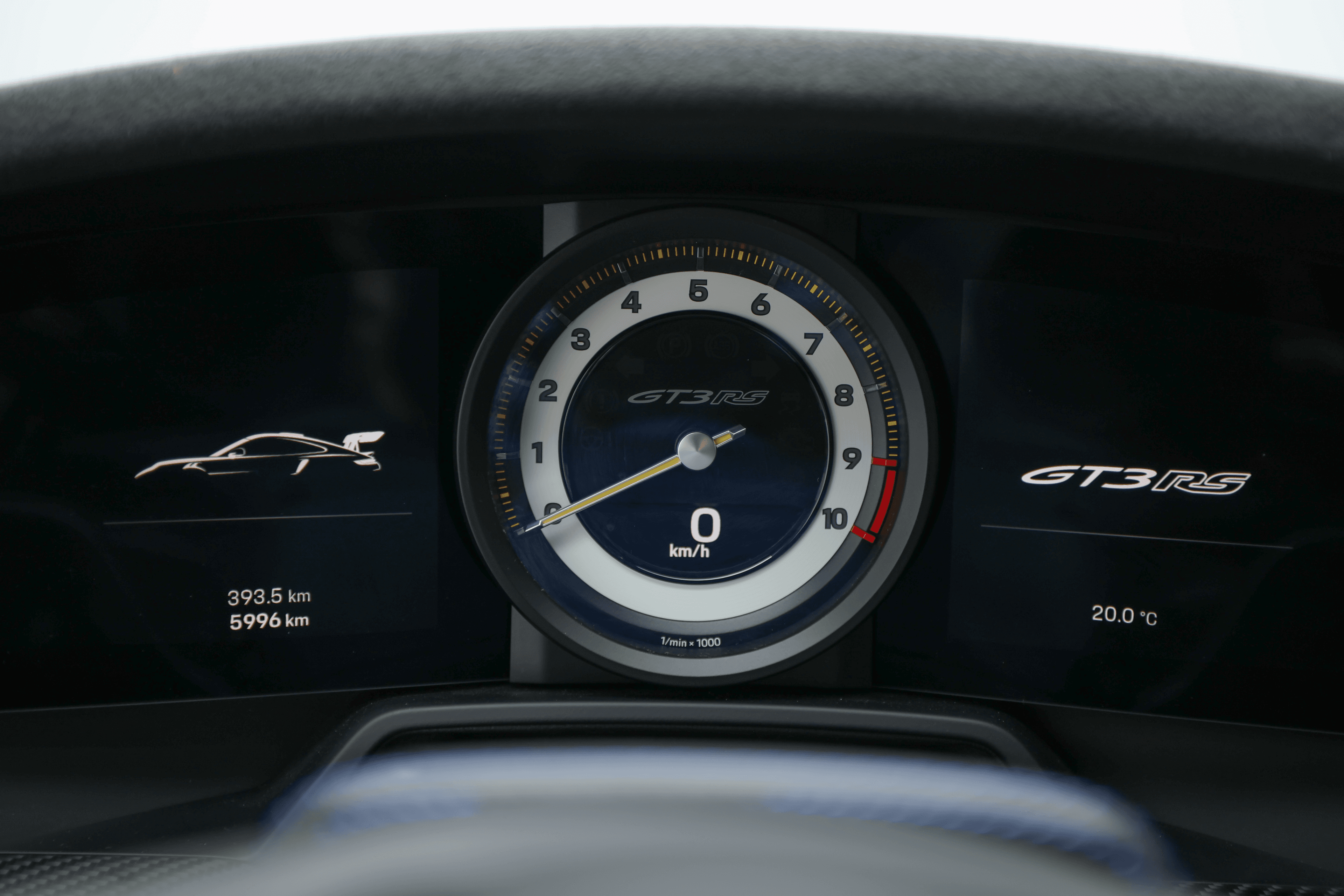 Affichage du tableau de bord de la Porsche GT3RS Shark blue, avec le compte-tours central et les informations sur la vitesse, illustrant la technologie avancée et le design orienté vers le conducteur.