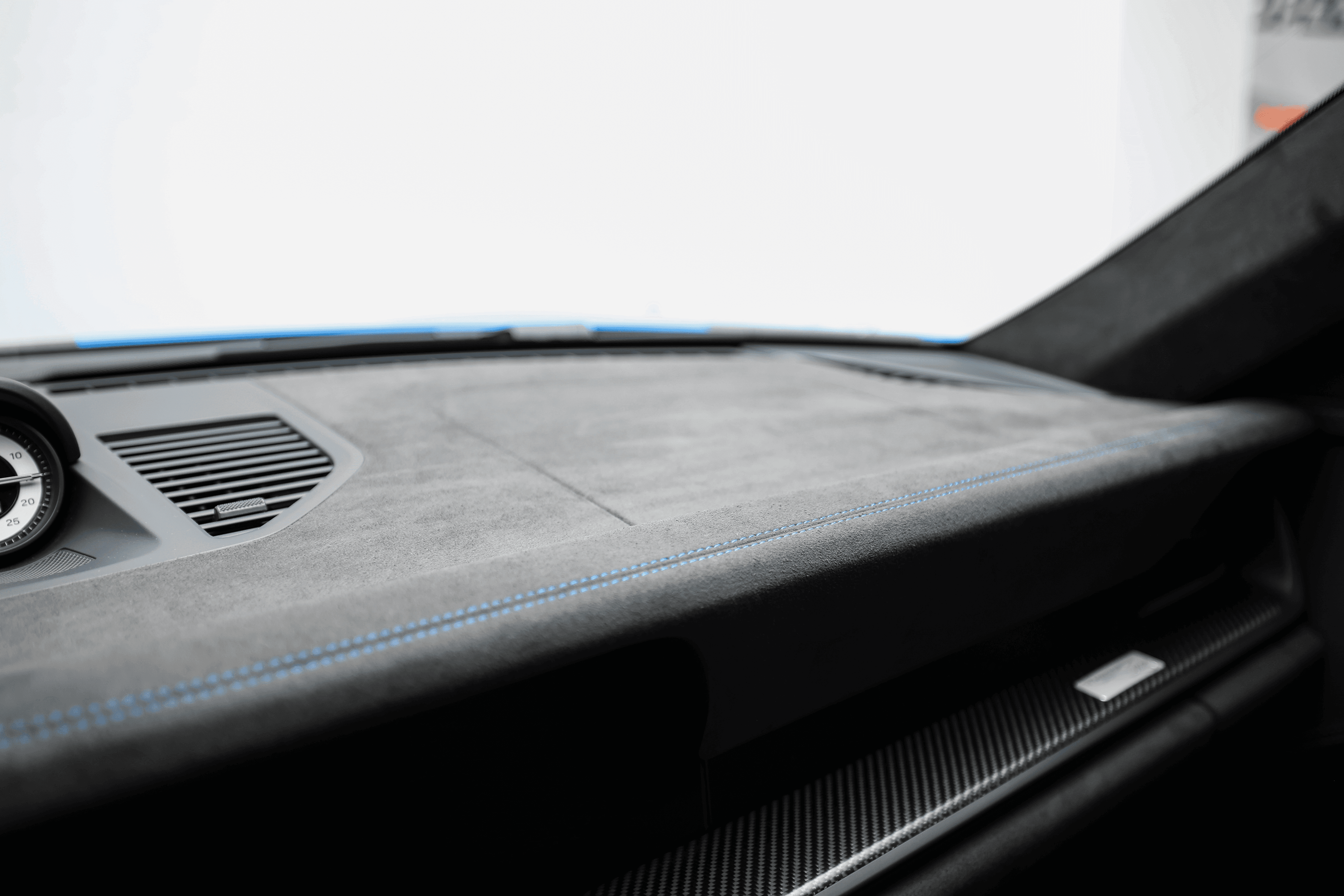 Détail du tableau de bord de la Porsche GT3RS bleue, mettant en avant les finitions en carbone et le design épuré, un mélange de luxe et de performance.
