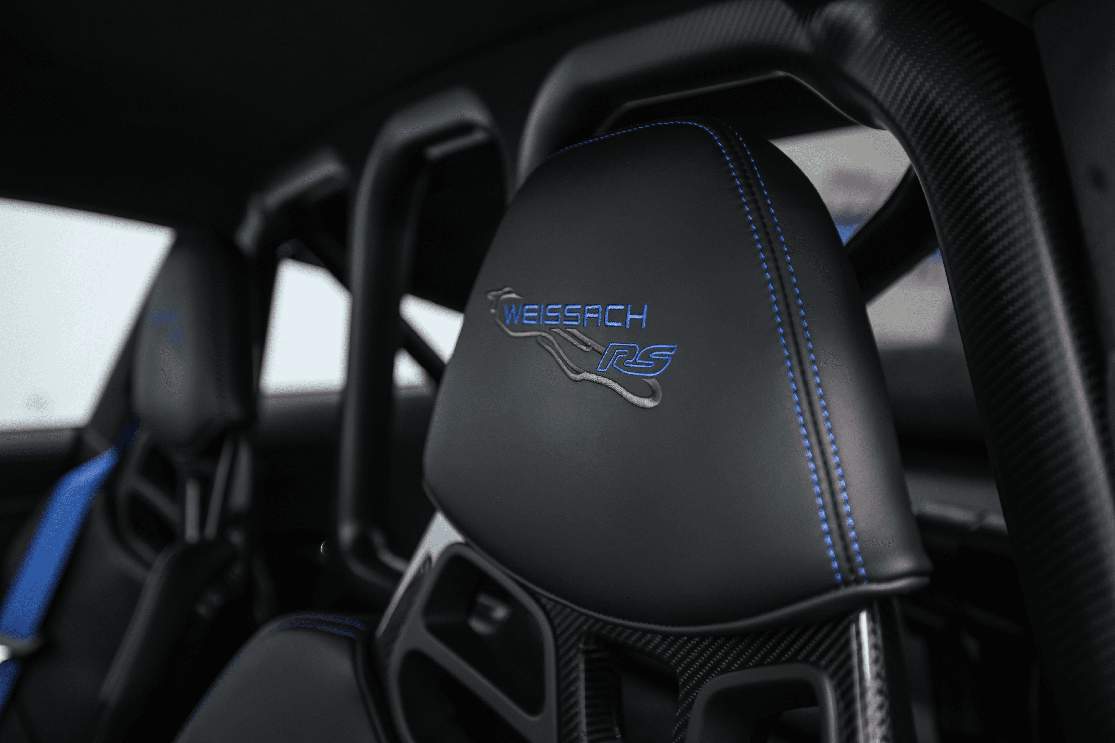 Détail du siège de la Porsche GT3RS bleue, avec l'insigne 'WEISSACH RS' brodé, soulignant l'orientation vers la performance et le confort du conducteur.
