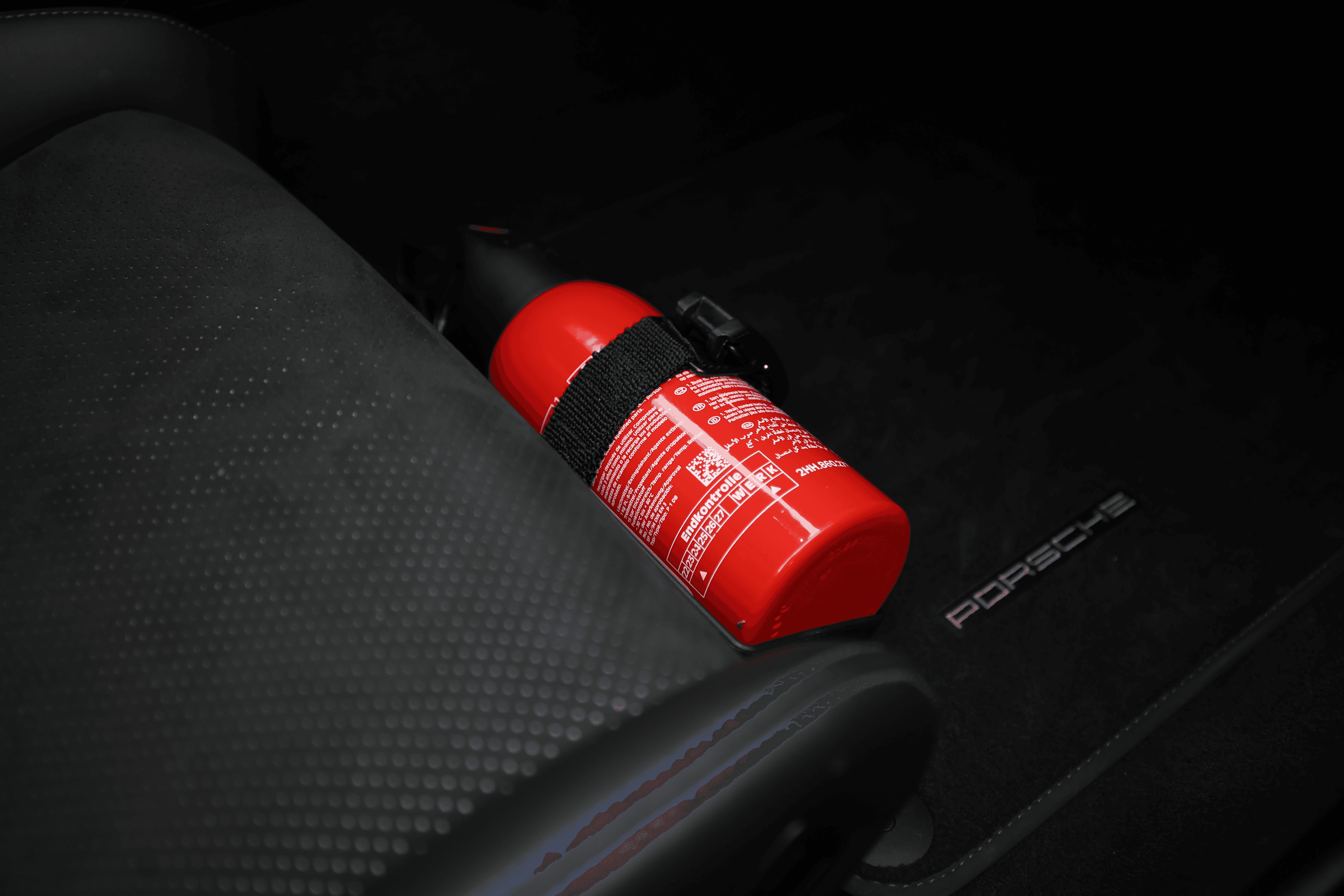 Détail de l'intérieur de la Porsche GT3RS, montrant un extincteur fixé sur le siège, soulignant les mesures de sécurité dans un cadre de performance.