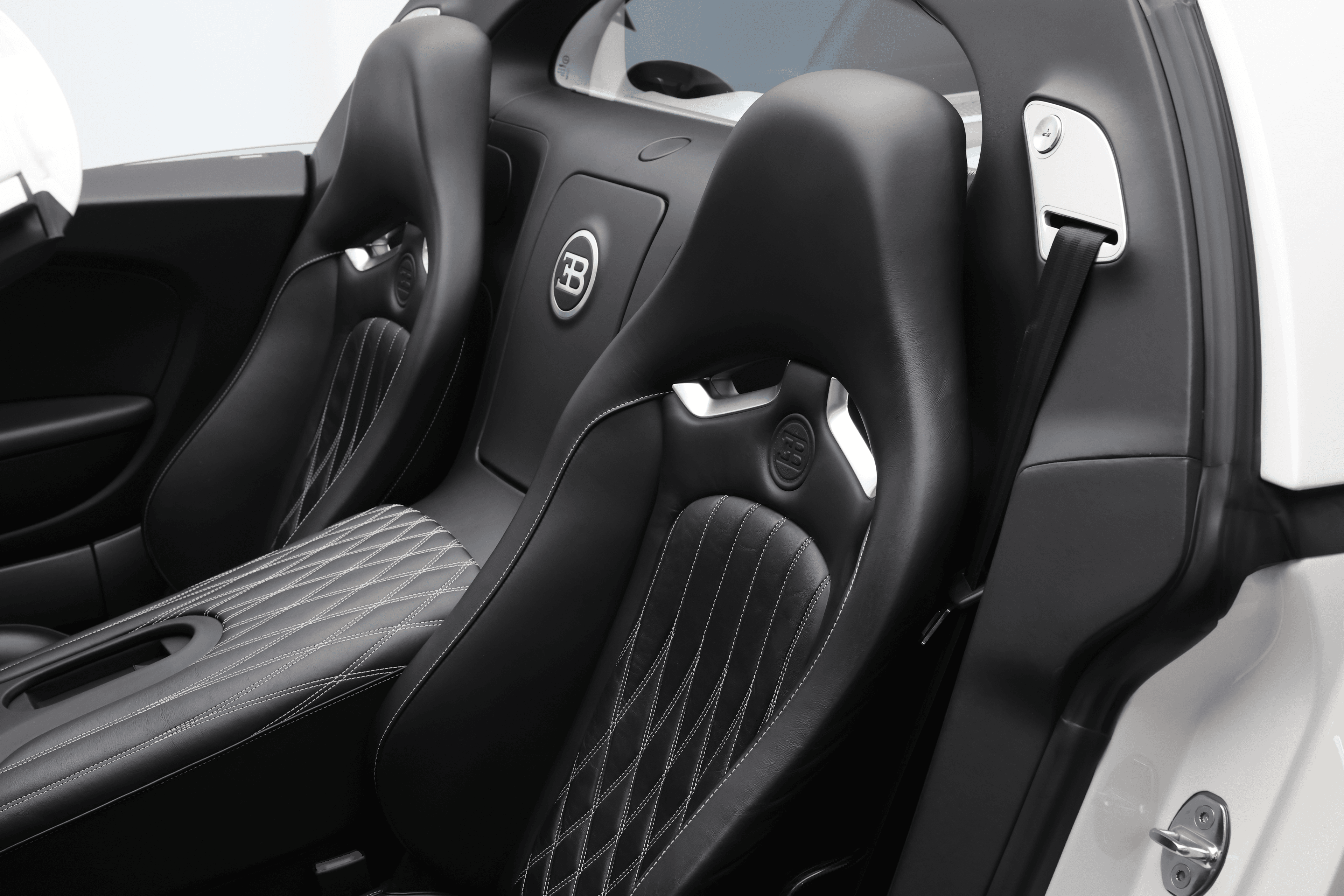 Les sièges de la Bugatti Veyron, habillés de cuir somptueux et ornés de surpiqûres délicates, allient confort et style, offrant une expérience de conduite luxueuse à chaque trajet.