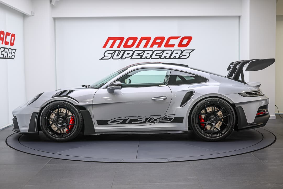 Cette vue de profil de la Porsche 911 GT3 RS met en exergue son profil élancé et ses courbes fluides, soulignant son aérodynamisme et sa silhouette emblématique qui évoquent la vitesse et la performance sur route.