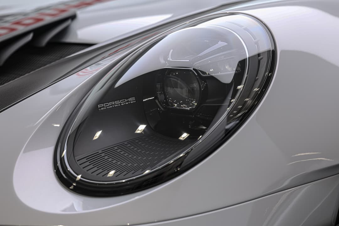 Ce gros plan sur le phare de la Porsche 911 GT3 RS révèle son design futuriste avec des éléments LED raffinés, accentuant à la fois l'agressivité et la précision de son éclairage, tout en soulignant l'ADN sportif de la marque.