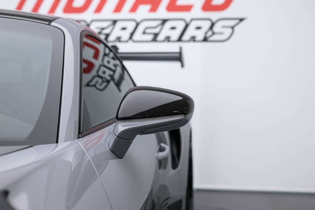 Cette vue détaillée du rétroviseur de la Porsche 911 GT3 RS met en avant son design aérodynamique et ses finitions soignées, illustrant l'attention portée aux détails qui améliore à la fois l'esthétique et la performance de ce véhicule d'exception.