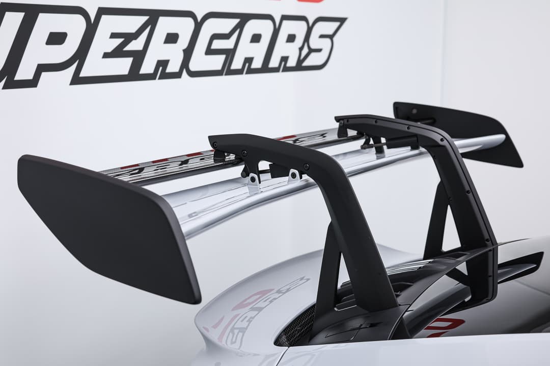 Cette vue des ailerons de la Porsche 911 GT3 RS révèle leur conception agressive et fonctionnelle, destinés à maximiser l'appui aérodynamique et à garantir une tenue de route exceptionnelle, tout en ajoutant une touche de style racing à l'ensemble.