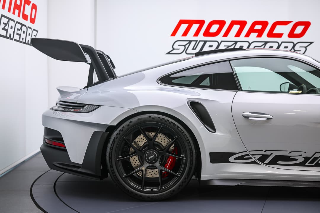 Cette image du latéral arrière de la Porsche 911 GT3 RS dévoile ses courbes aérodynamiques et sa silhouette musclée, mettant en évidence l'intégration harmonieuse des éléments de design qui renforcent à la fois son allure sportive et son efficacité sur la route.