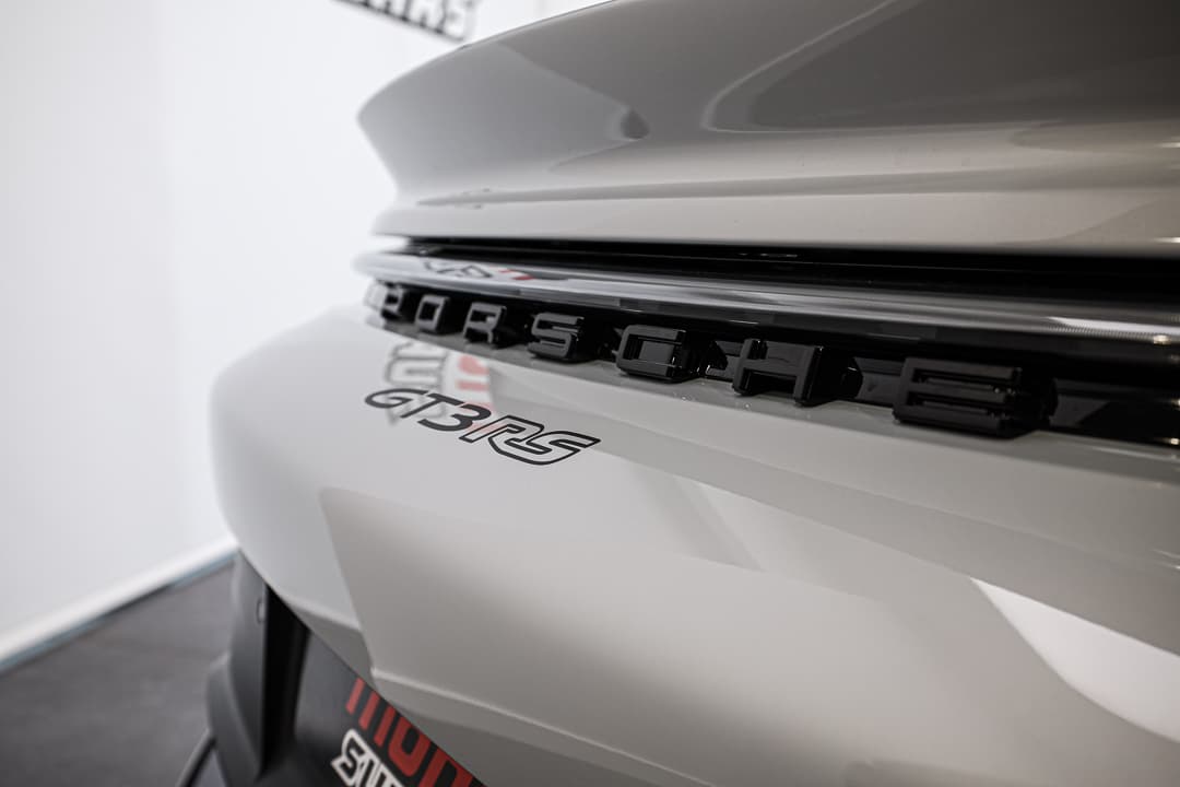 Cette image du logo Porsche en relief capte l'essence de la marque, avec ses détails raffinés qui évoquent le luxe et l'ingénierie de précision, tout en ajoutant une dimension tactile et visuelle à l'identité emblématique de la voiture.