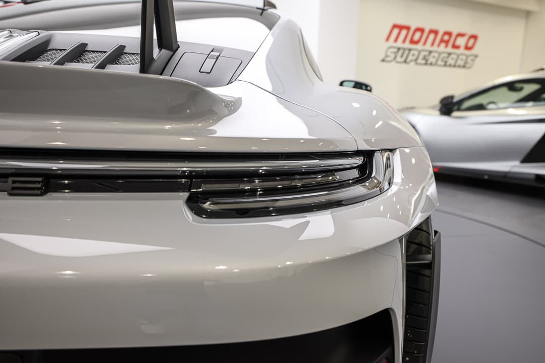 Cette vue des feux arrière de la Porsche 911 GT3 RS révèle un design élégant et moderne, avec des lignes nettes et une technologie d'éclairage avancée qui accentuent le caractère dynamique de la voiture, tout en assurant une visibilité optimale sur la route.