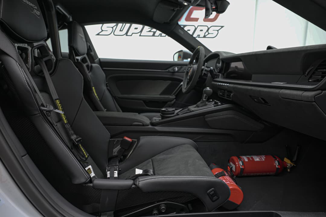 Cette image de l'intérieur côté passager de la Porsche 911 GT3 RS montre un espace raffiné, avec des matériaux haut de gamme, des finitions élégantes et un accent sur le confort, offrant une expérience de voyage tout aussi dynamique et stylée que celle du conducteur.