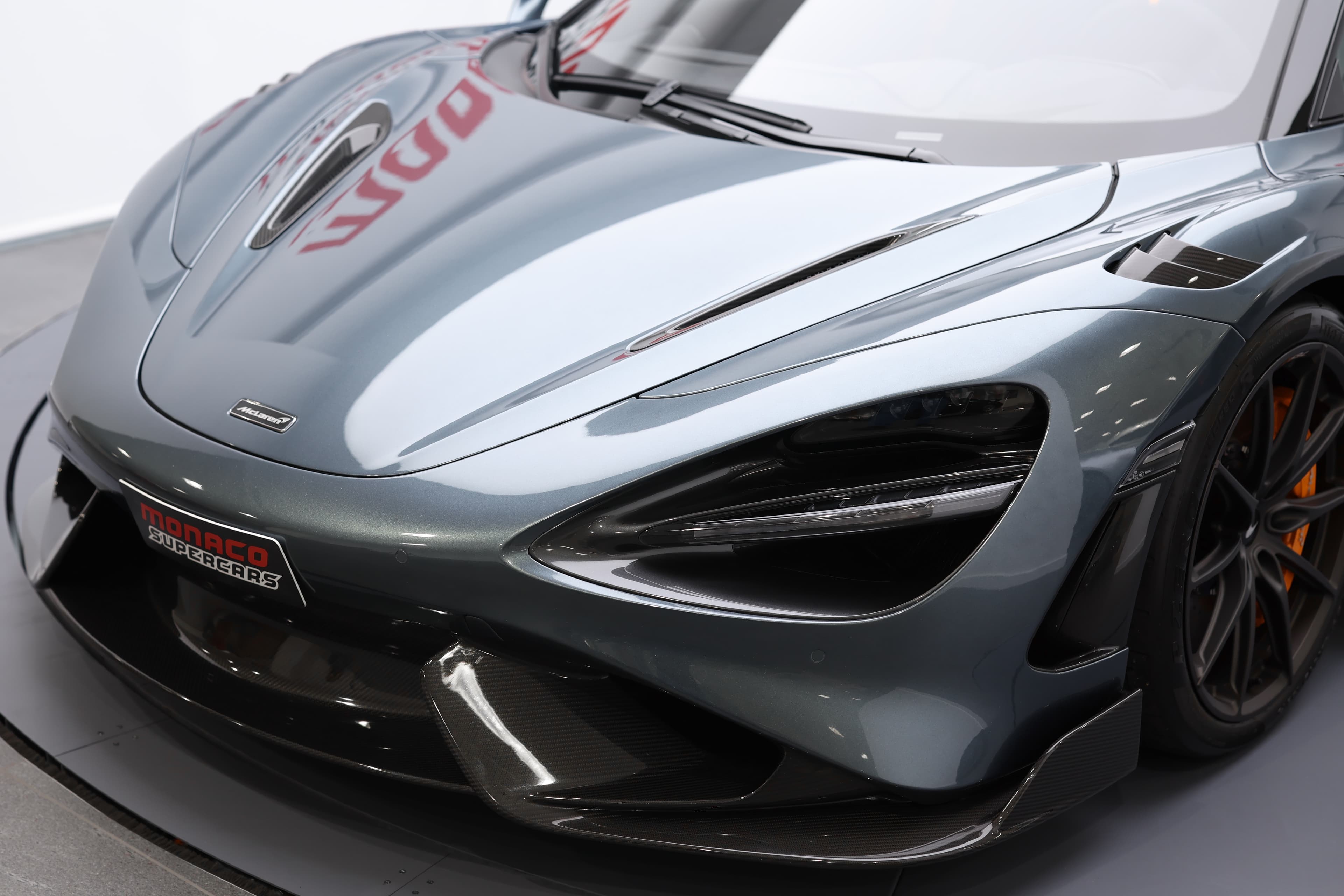 L'image met en avant le capot avant de la McLaren 765LT, soulignant ses lignes agressives et son design aérodynamique, qui reflètent la performance et l'innovation caractéristiques de la marque.