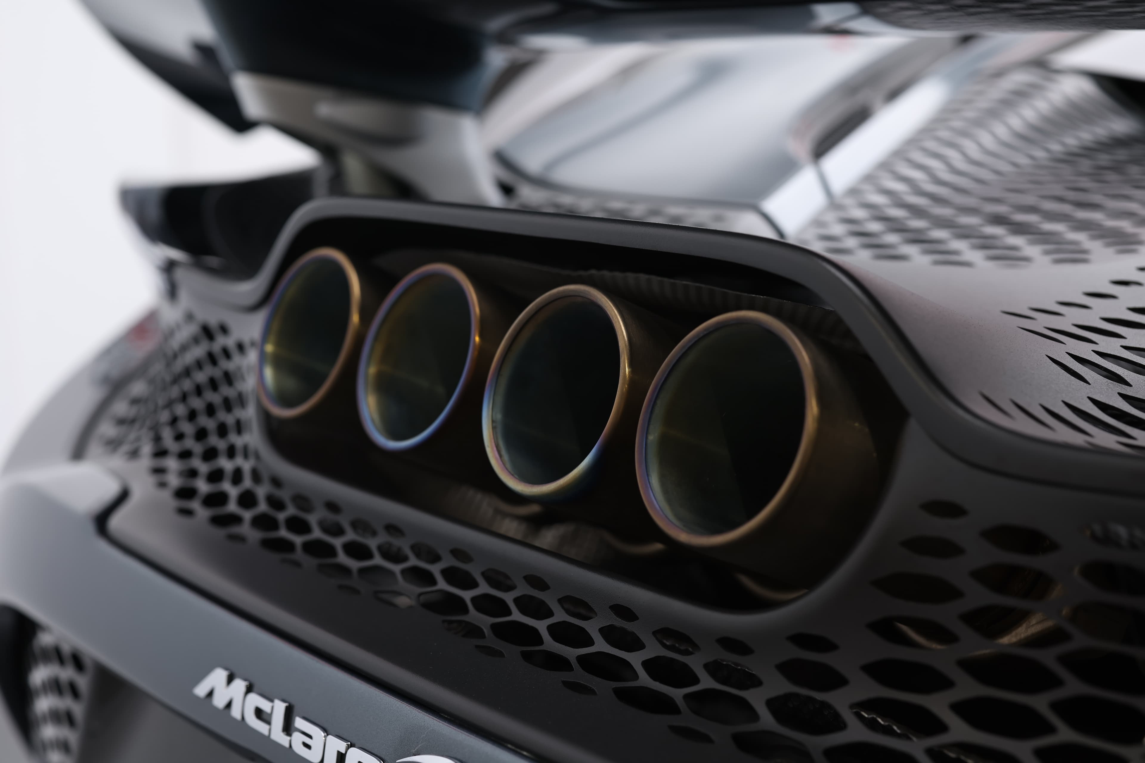 L'image se concentre sur le système d'échappement arrière de la McLaren 765LT, mettant en valeur son design distinctif et sportif, qui contribue à la performance sonore et à l'efficacité aérodynamique du véhicule.
