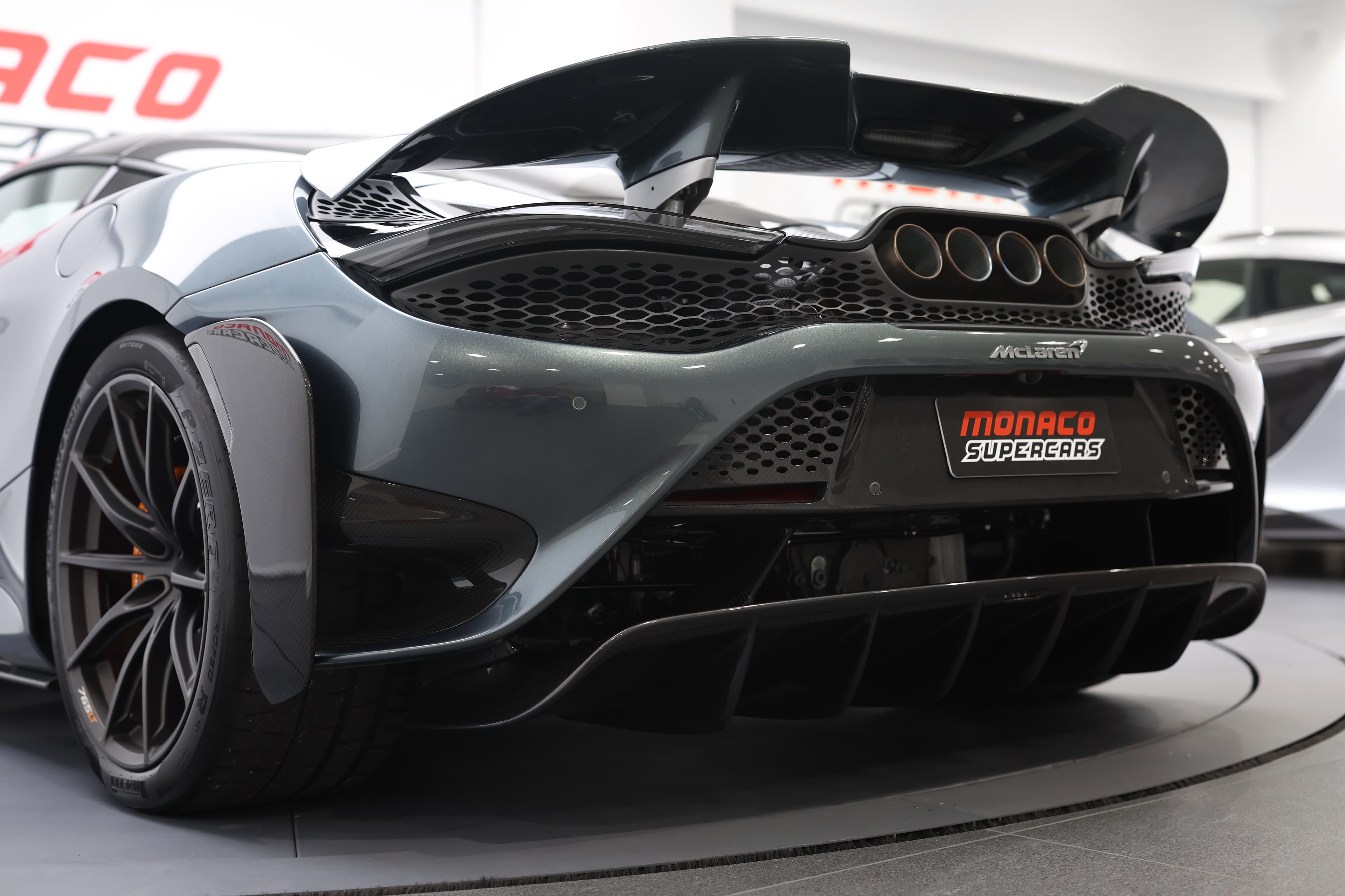 L'image met en avant le diffuseur arrière de la McLaren 765LT, soulignant son design complexe et fonctionnel, qui améliore l'aérodynamisme et l'appui, tout en ajoutant une touche agressive à l'arrière de la voiture.