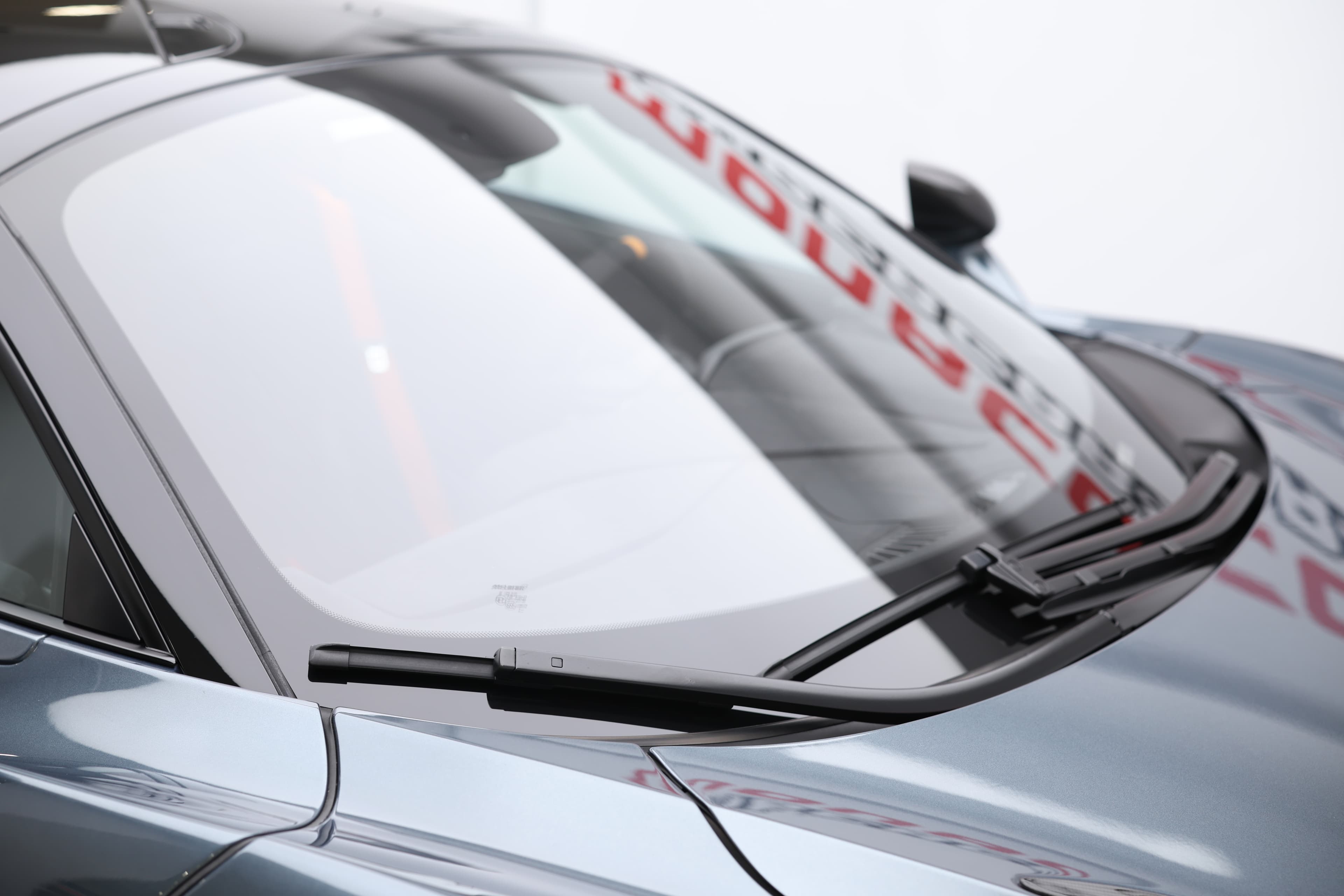 L'image se concentre sur le pare-brise de la McLaren 765LT, mettant en avant sa forme aérodynamique et son intégration fluide dans le design général de la voiture, contribuant à la visibilité et à l'esthétique sportive.