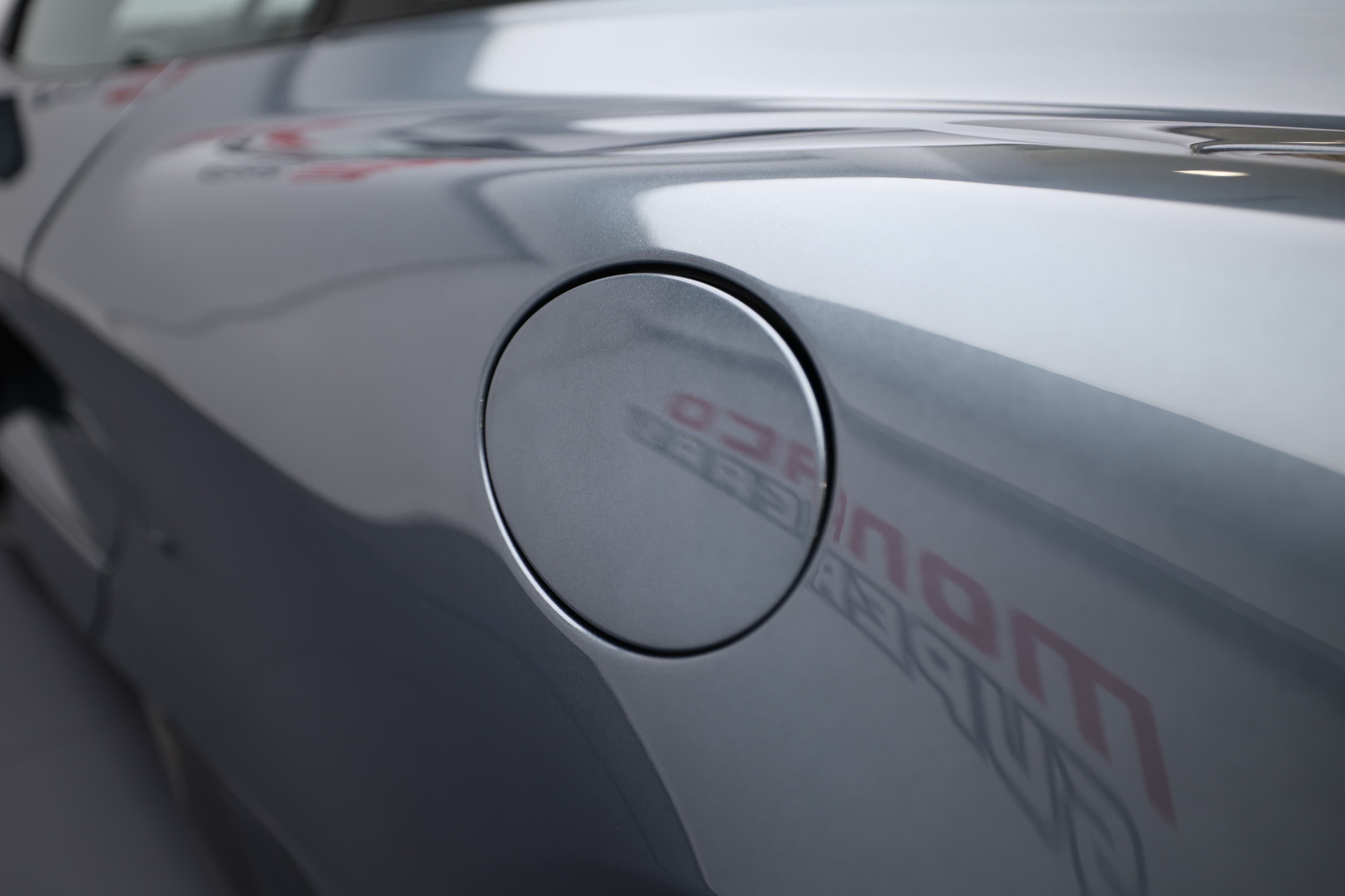 L'image montre la trappe à essence de la McLaren 765LT, mettant en avant son design élégant et fonctionnel, qui s'intègre parfaitement à la carrosserie tout en ajoutant une touche sportive au style général du véhicule.