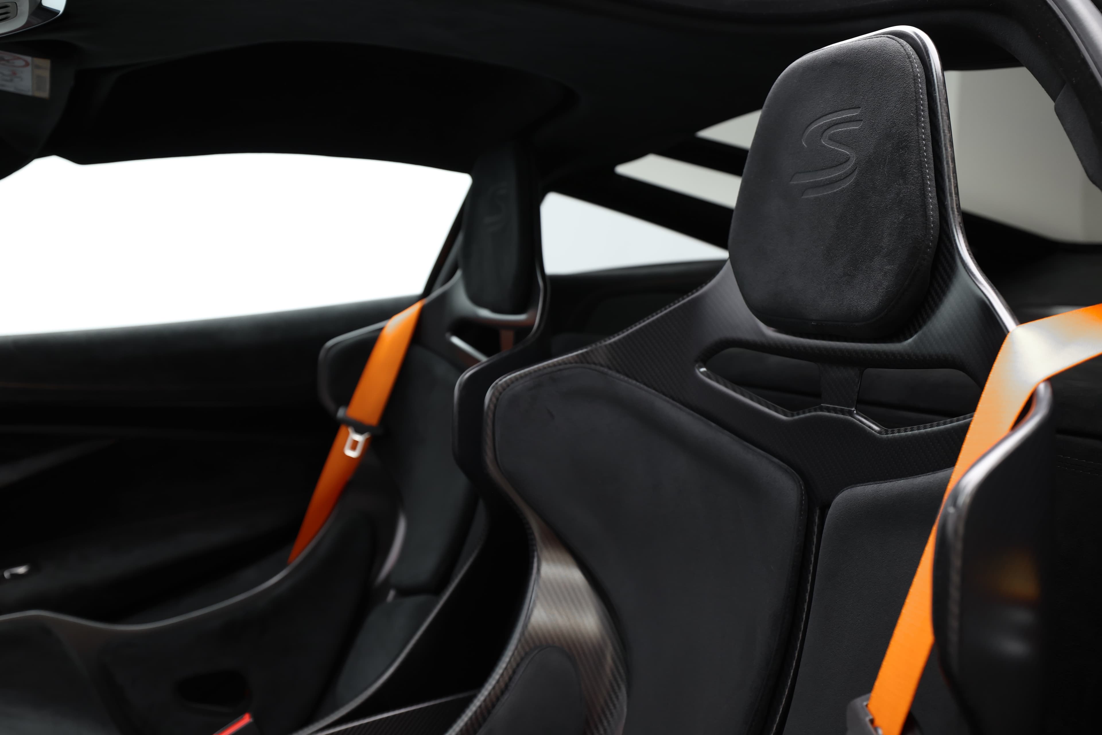 L'image met en avant le siège de la McLaren Senna, célèbre pour son design ergonomique et sportif. Le siège est souvent en fibre de carbone, offrant un soutien optimal pour la conduite dynamique. Son allure est à la fois agressive et luxueuse, reflétant la performance exceptionnelle de ce modèle.