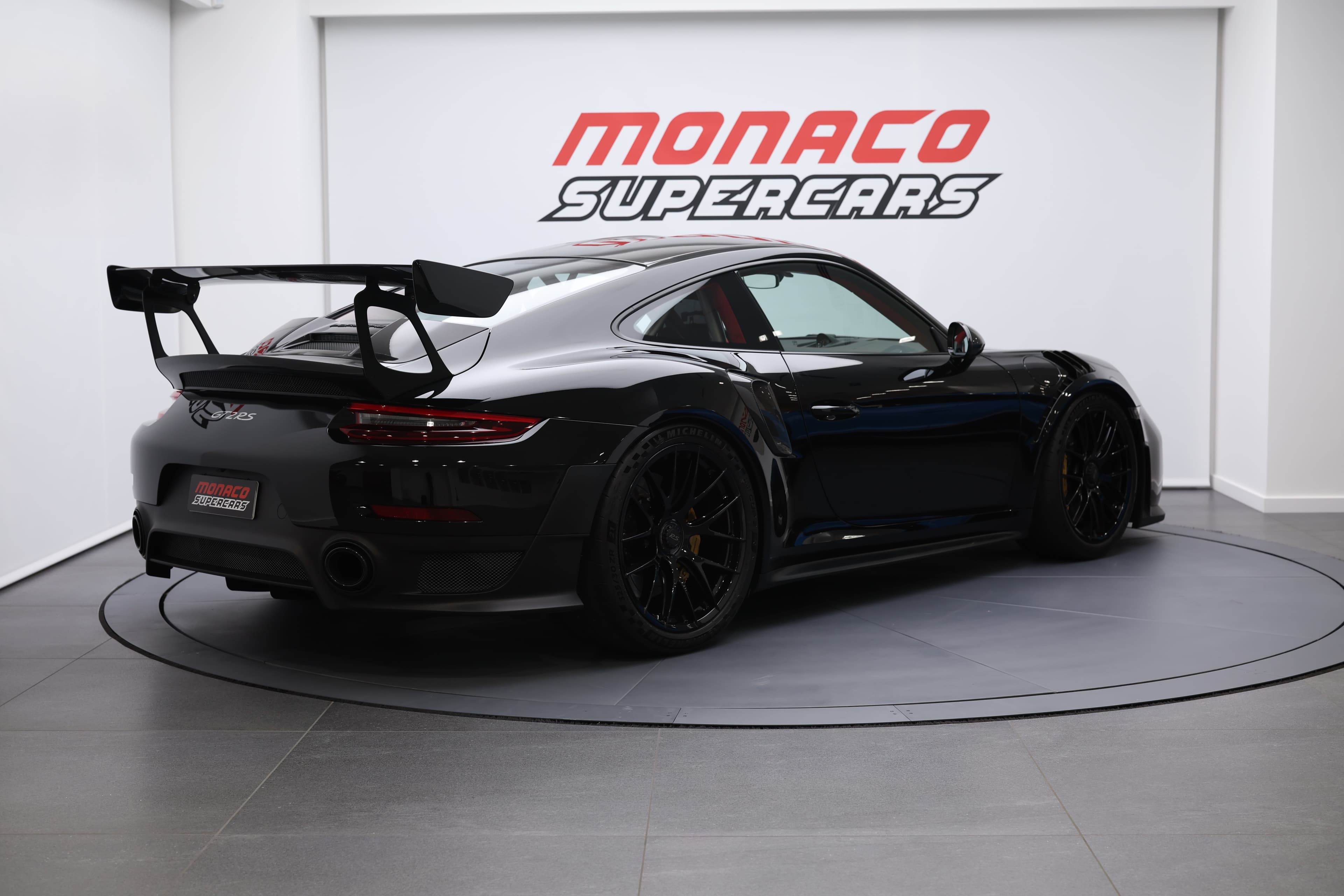 À vendre, Porsche 911 GT2 RS noire, 3/4 arrière, supercar de luxe, performances exceptionnelles, design aérodynamique, moteur puissant, traction arrière, Monaco, collection exclusive.
