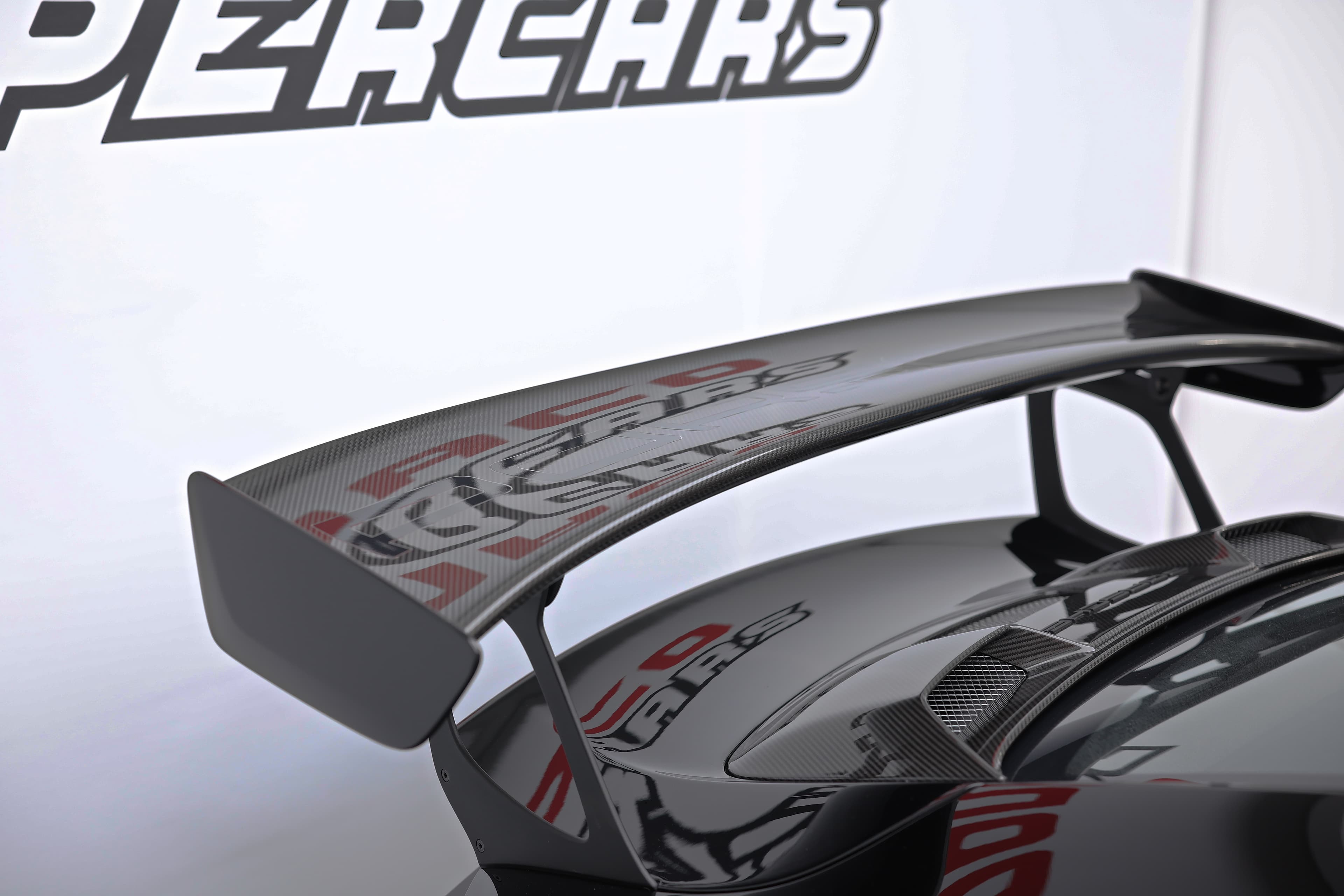 Photo de l'aileron de la Porsche 911 GT2 RS noire, mettant en avant son design aérodynamique et sportif, essentiel pour la performance de cette supercar.