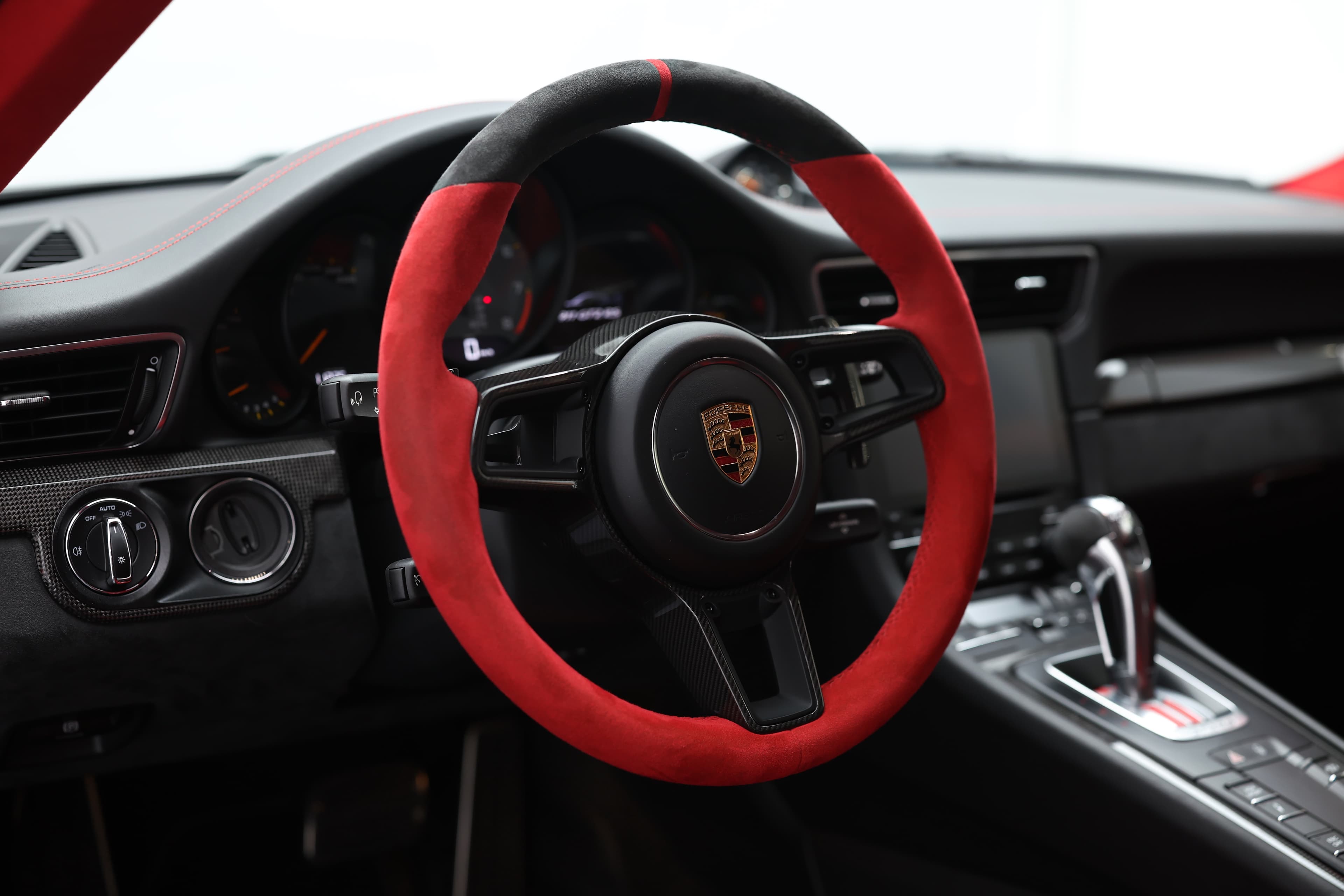 Photo du volant en Alcantara noir et rouge de la Porsche 911 GT2 RS, offrant une prise en main optimale et un style audacieux qui accentue l'aspect sportif de l'intérieur.