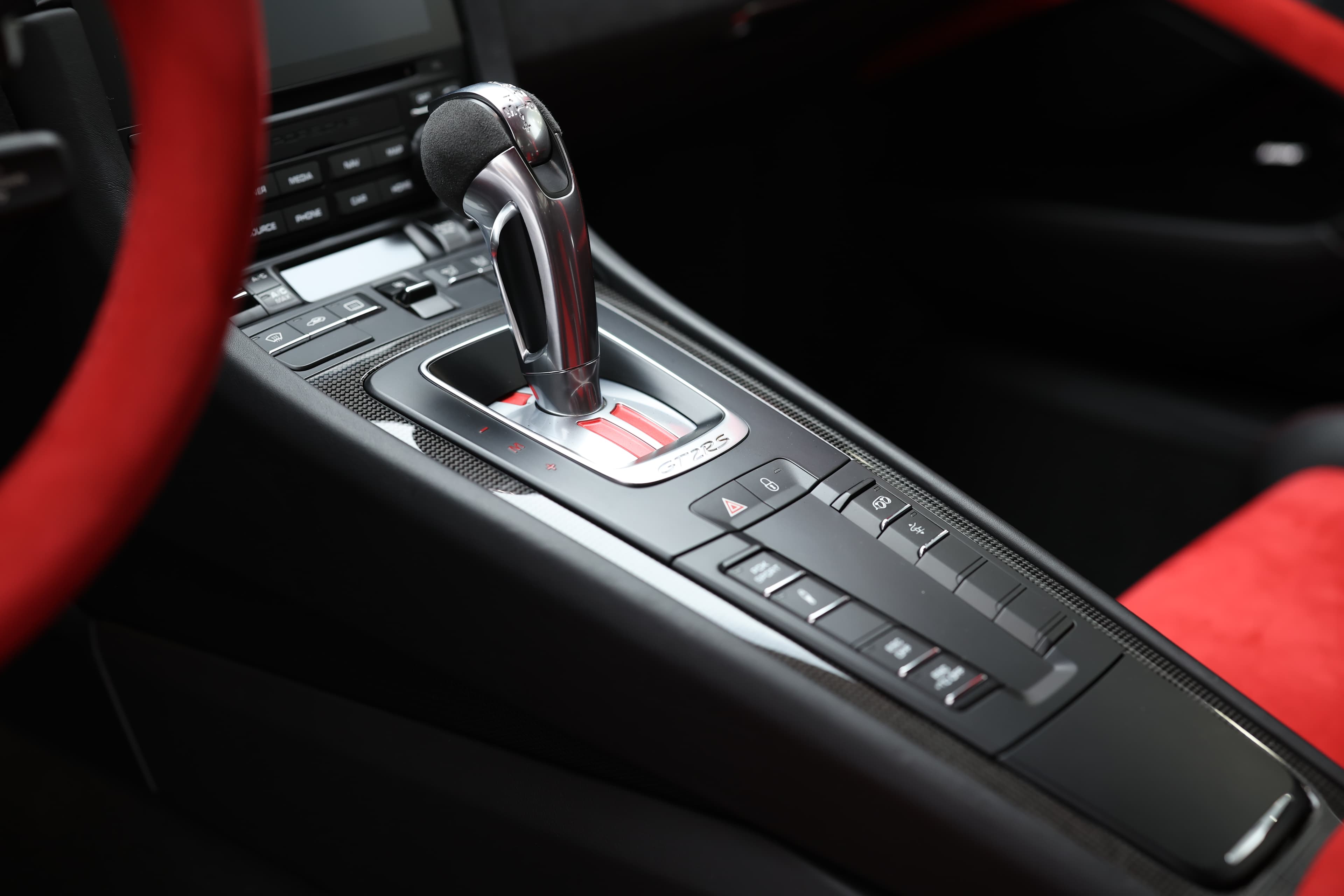 Photo de la console centrale de la Porsche 911 GT2 RS, intégrant des commandes intuitives et un design élégant, reflétant l'harmonie entre performance et technologie.