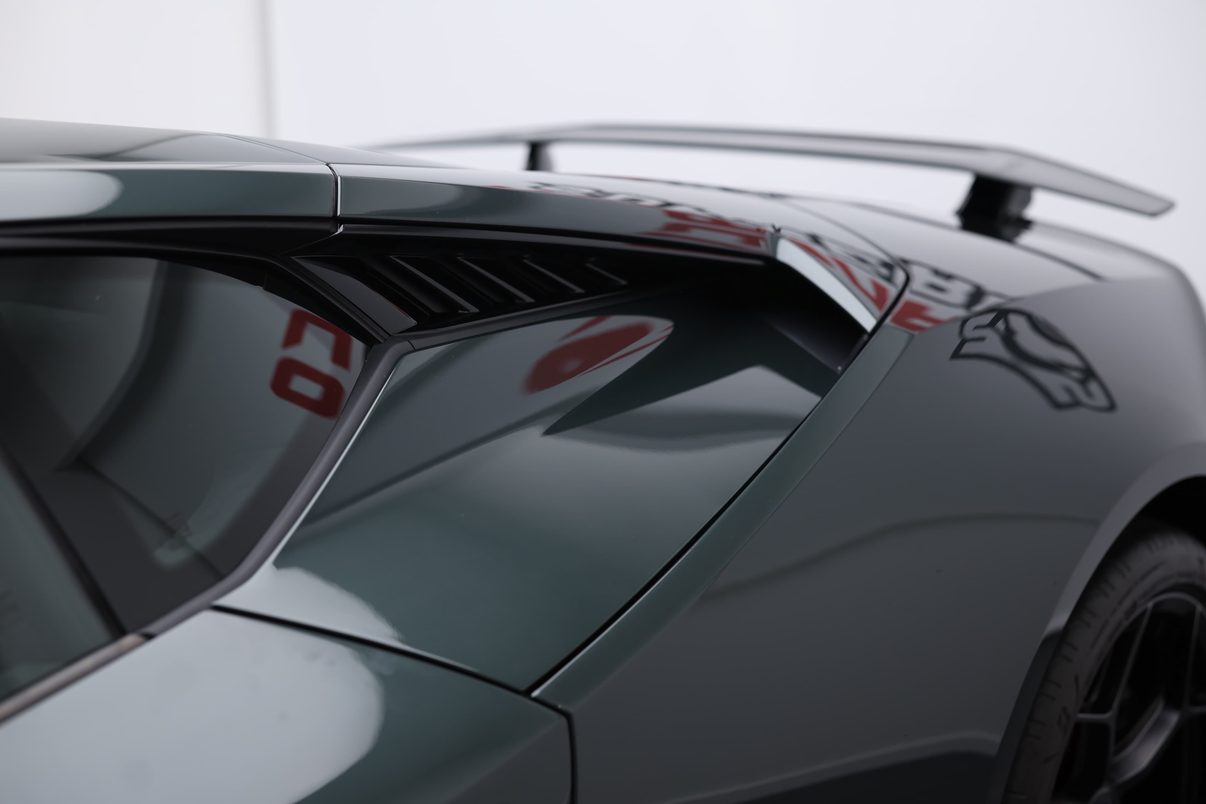 La Lamborghini Huracán Tecnica, vue de profil avec une légère inclinaison vers l'avant, dévoile son design sculptural et ses lignes fluides, mettant en avant la puissance de son moteur V10 et l'élégance de sa vitre arrière.