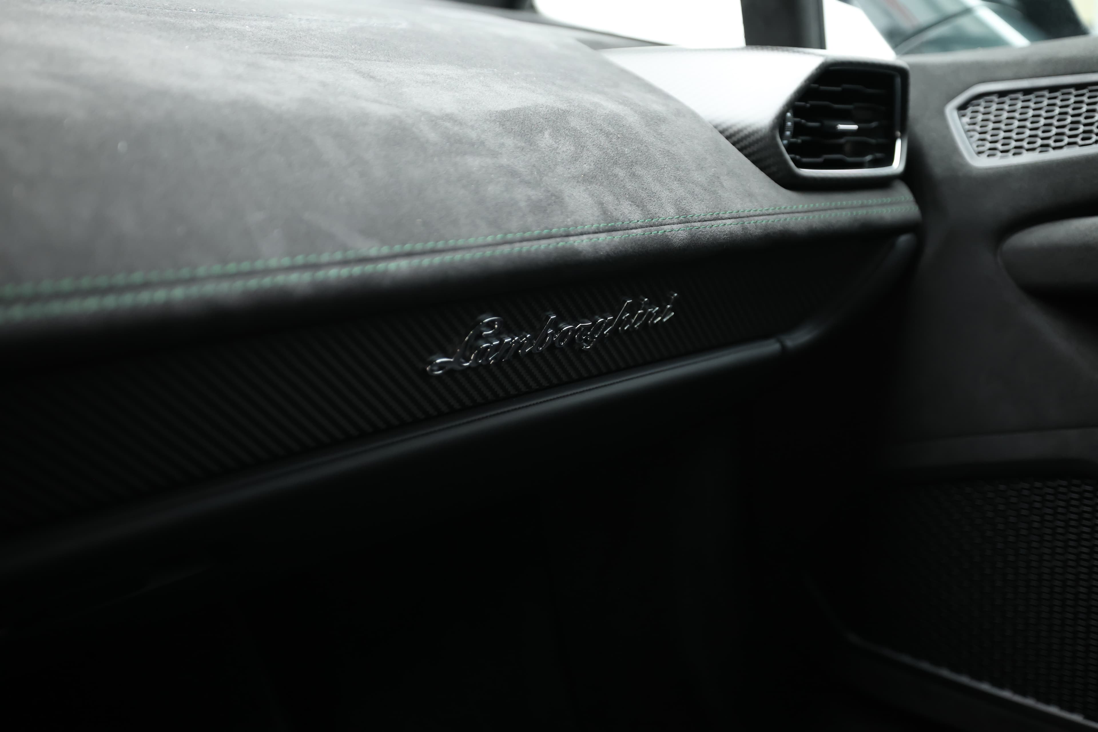 Le tableau de bord de la Lamborghini Huracán Tecnica arbore des finitions en carbone, créant une atmosphère sportive et luxueuse. Le logo Lamborghini est intégré de manière distinctive, tandis que les commandes et les écrans numériques ajoutent une touche moderne et fonctionnelle, offrant au conducteur une interface intuitive et élégante.