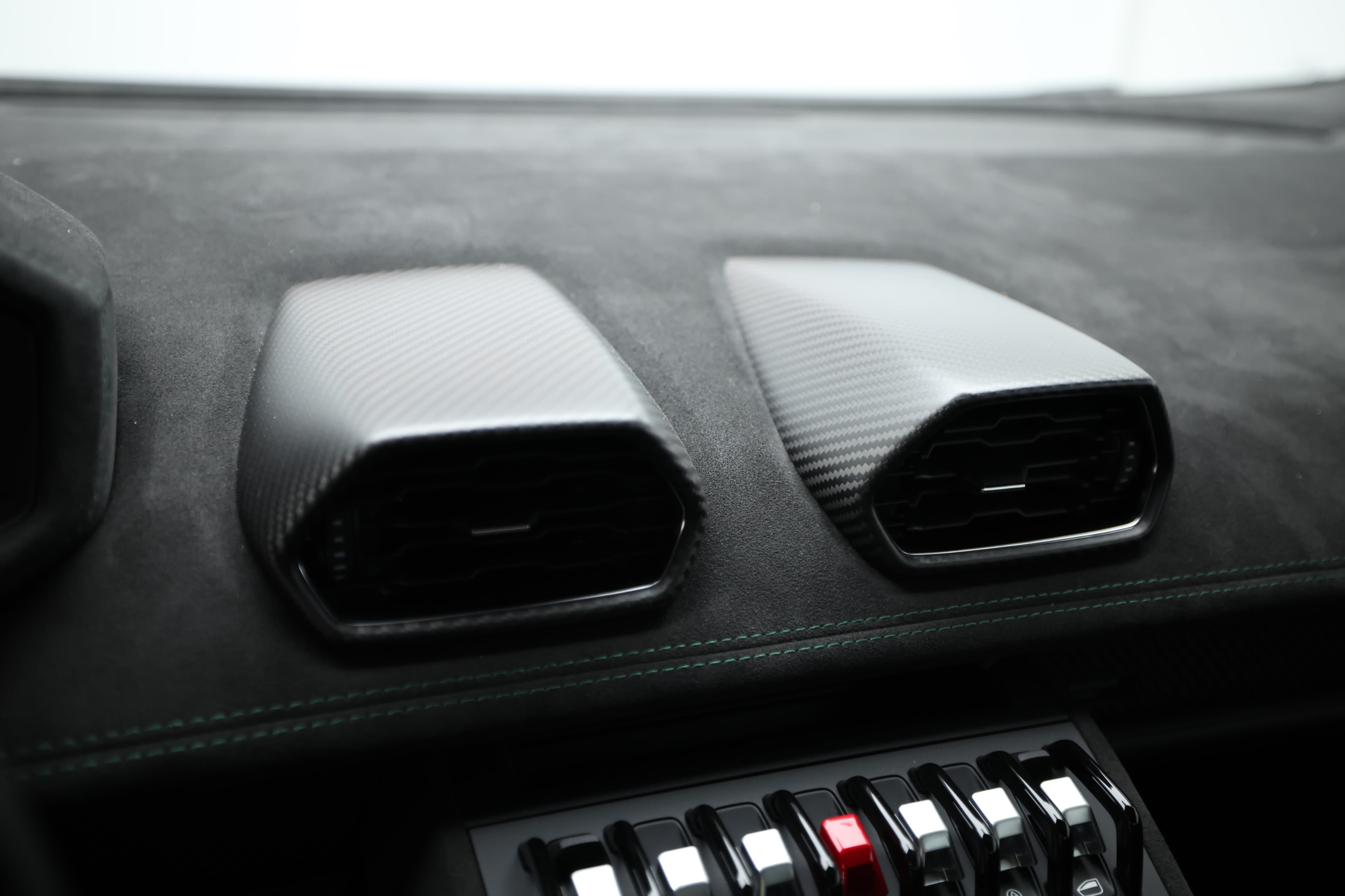 Les aérations centrales de la Lamborghini Huracán Tecnica sont élégamment intégrées dans un design en carbone, offrant non seulement une fonctionnalité optimale pour la climatisation, mais aussi un accent sportif qui s’harmonise parfaitement avec l’esthétique globale de l’habitacle.