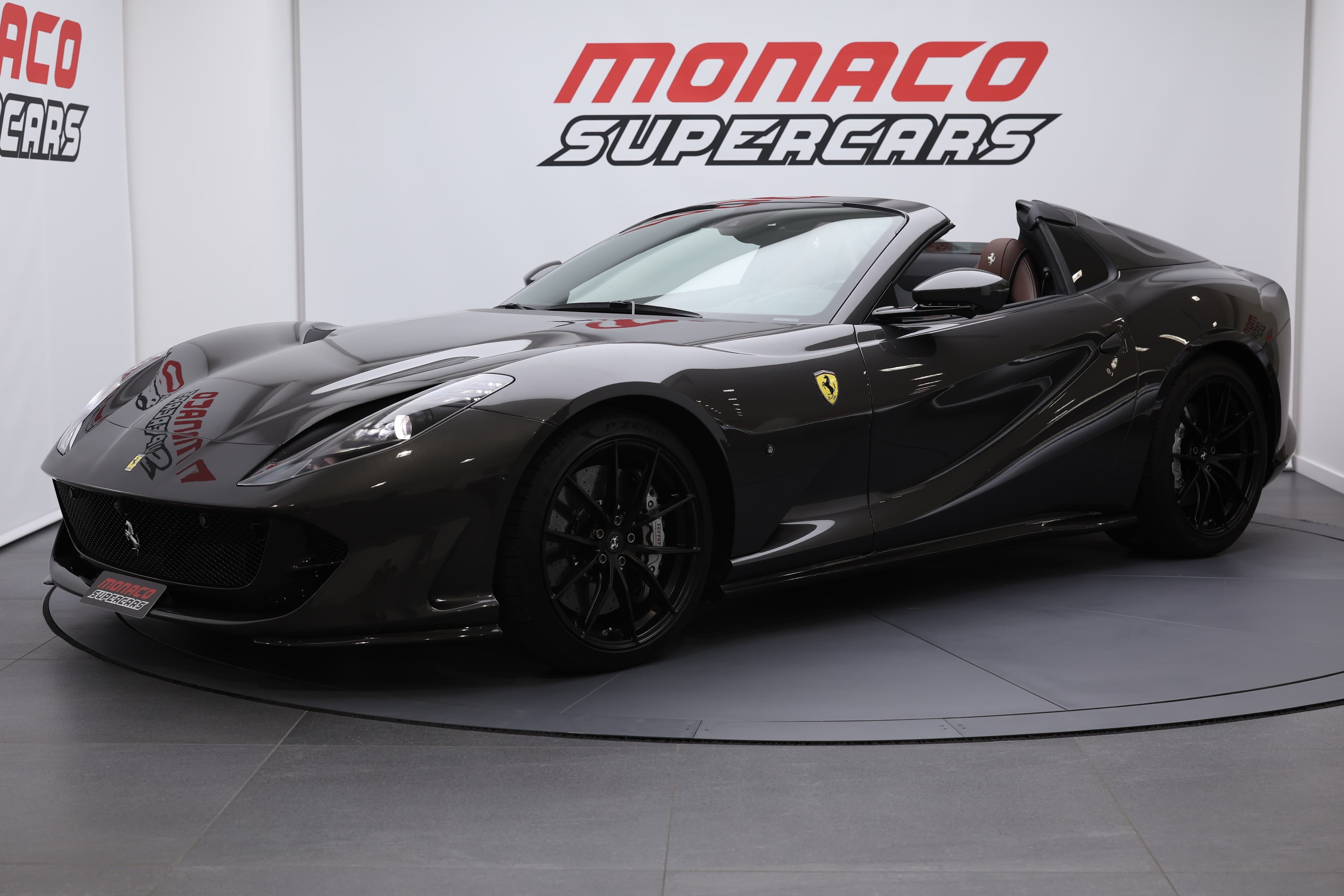 La Ferrari 812 GTS, décapotée et vue de 3/4 avant, offre une expérience visuelle saisissante, mettant en valeur son design élégant, les courbes fluides de sa carrosserie et l'intérieur raffiné, tout en révélant le puissant moteur V12 qui promet des sensations de conduite inoubliables.