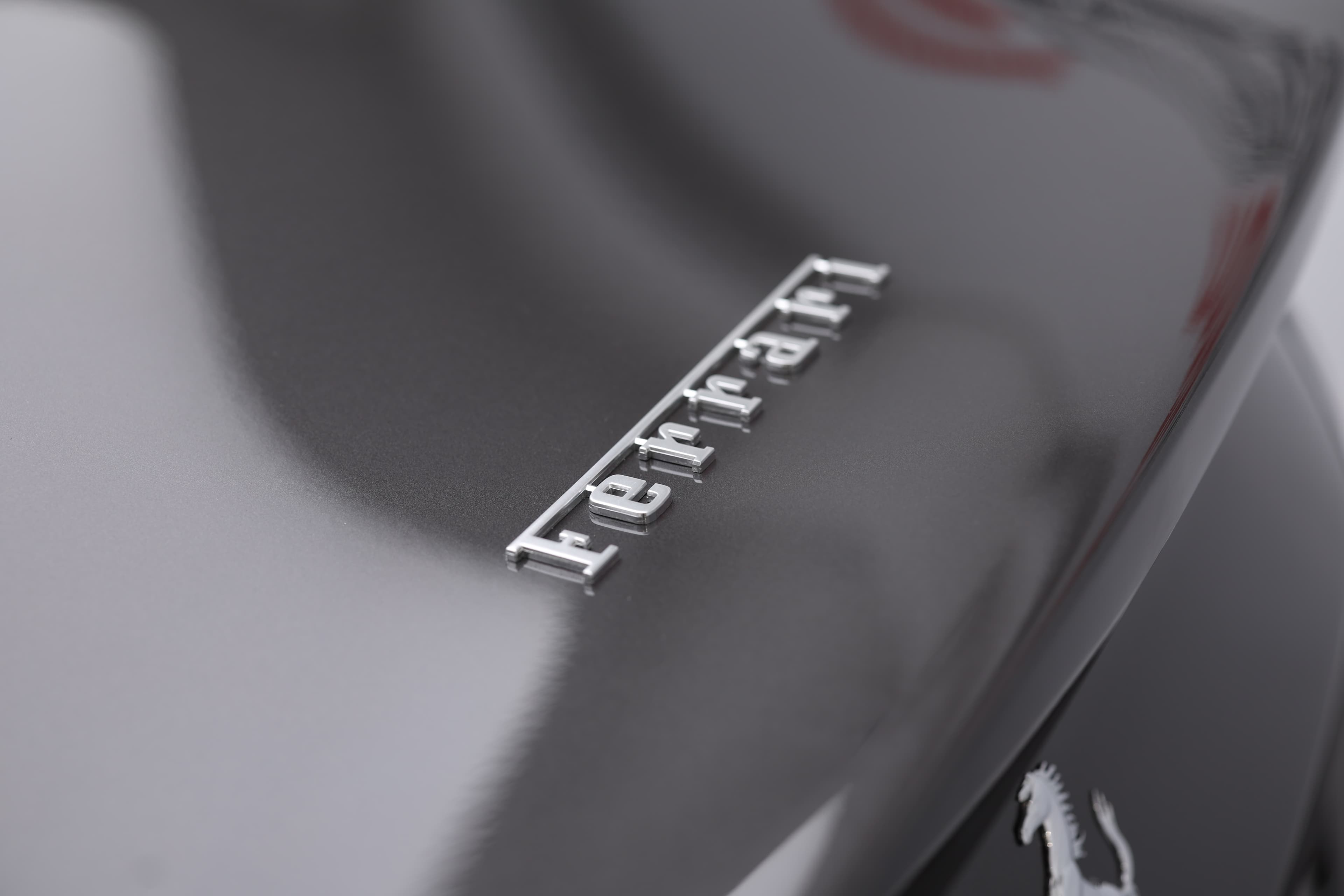 Le logo Ferrari, représentant un cheval cabré sur fond jaune, symbolise la vitesse, le luxe et l'héritage légendaire de la marque italienne.