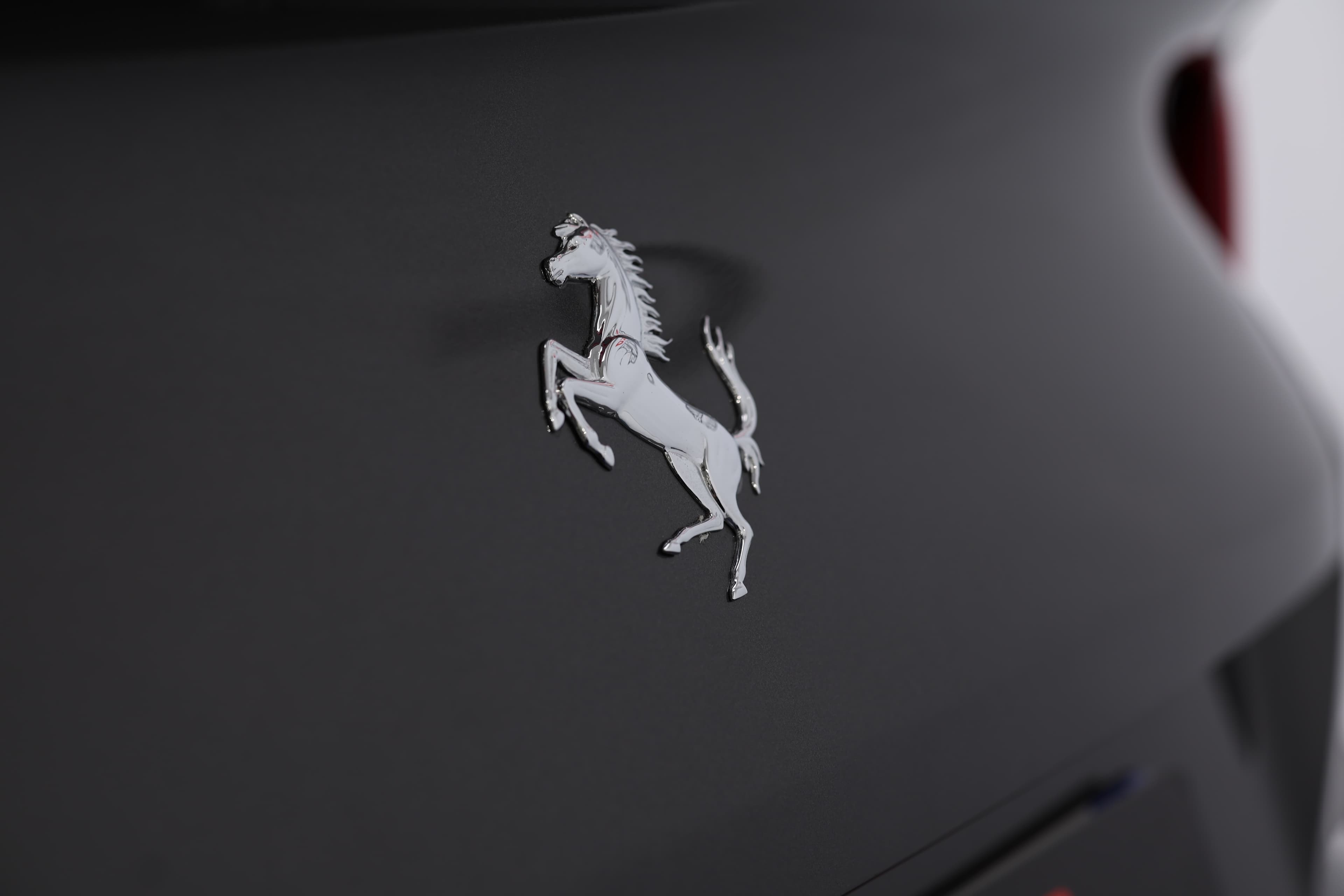Le logo Ferrari, représentant un cheval cabré sur fond jaune, symbolise la vitesse, le luxe et l'héritage légendaire de la marque italienne.