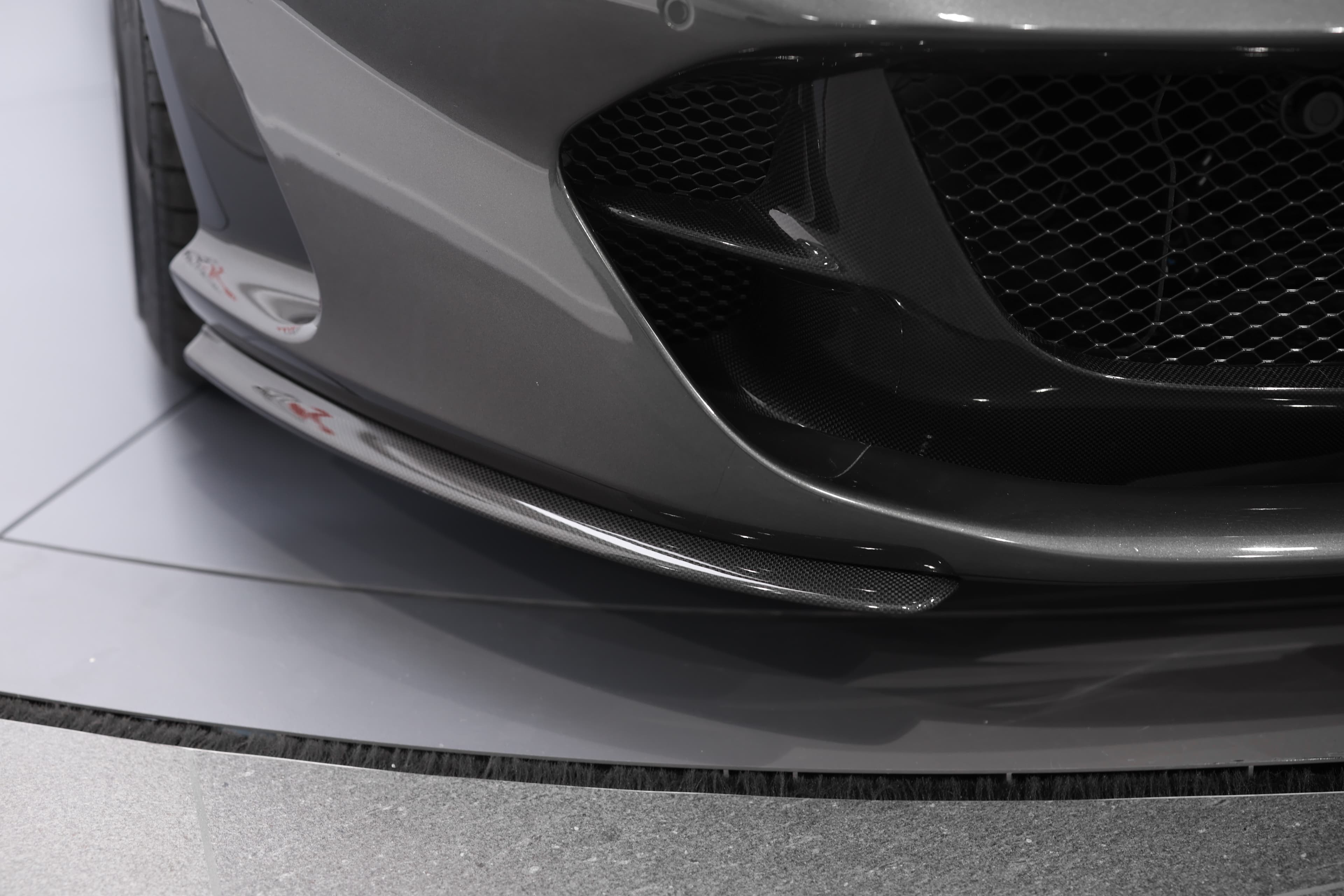 Les feux avant de la Ferrari 812 GTS, au design agressif et anguleux, intègrent des technologies LED avancées, soulignant son caractère dynamique tout en assurant une visibilité optimale.