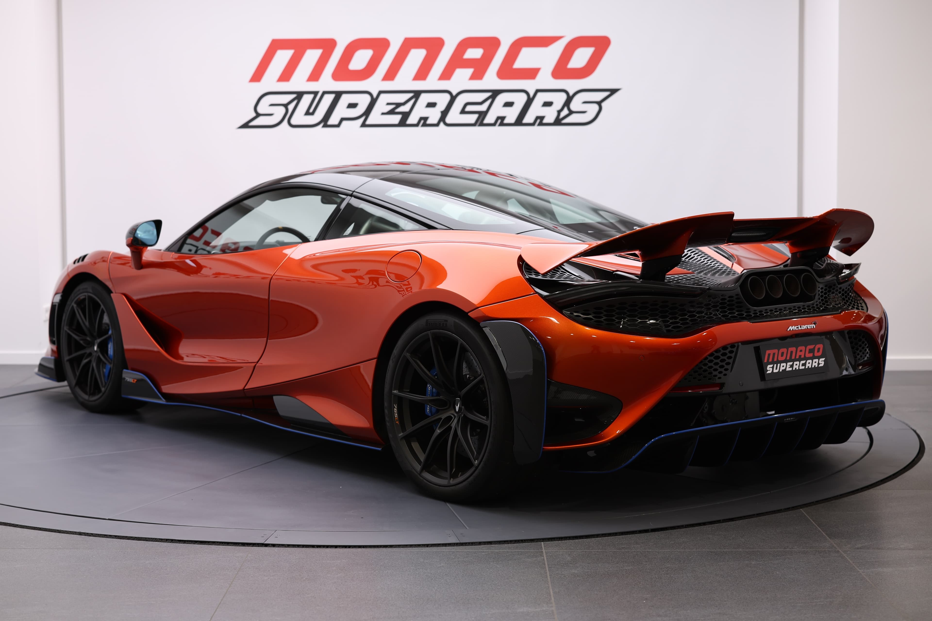 Vue latérale et arrière de la McLaren 765LT, mettant en avant son aileron arrière et son design sculpté, soulignant l'accent mis sur l'aérodynamisme et la performance.