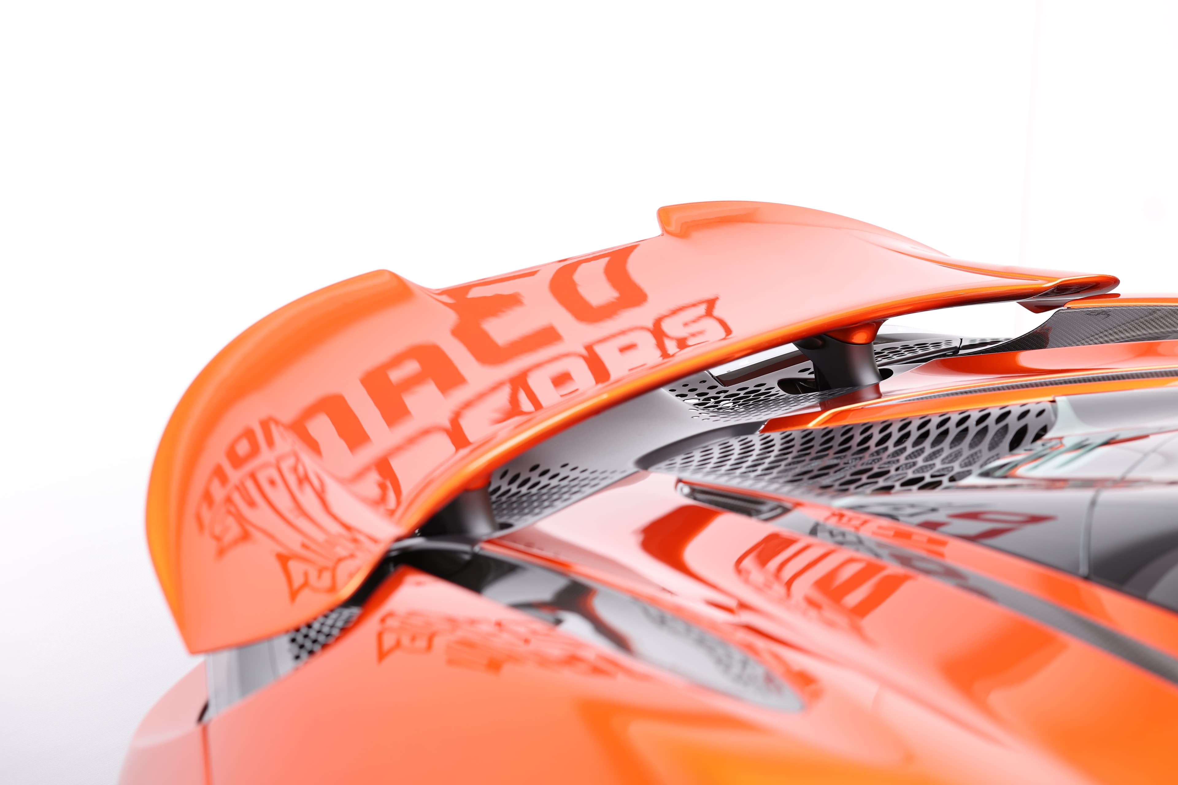 Gros plan sur l'aileron arrière de la McLaren 765LT, mettant en avant son design aérodynamique et les détails en carbone, illustrant l'importance de l'appui aérodynamique pour la performance de cette supercar.