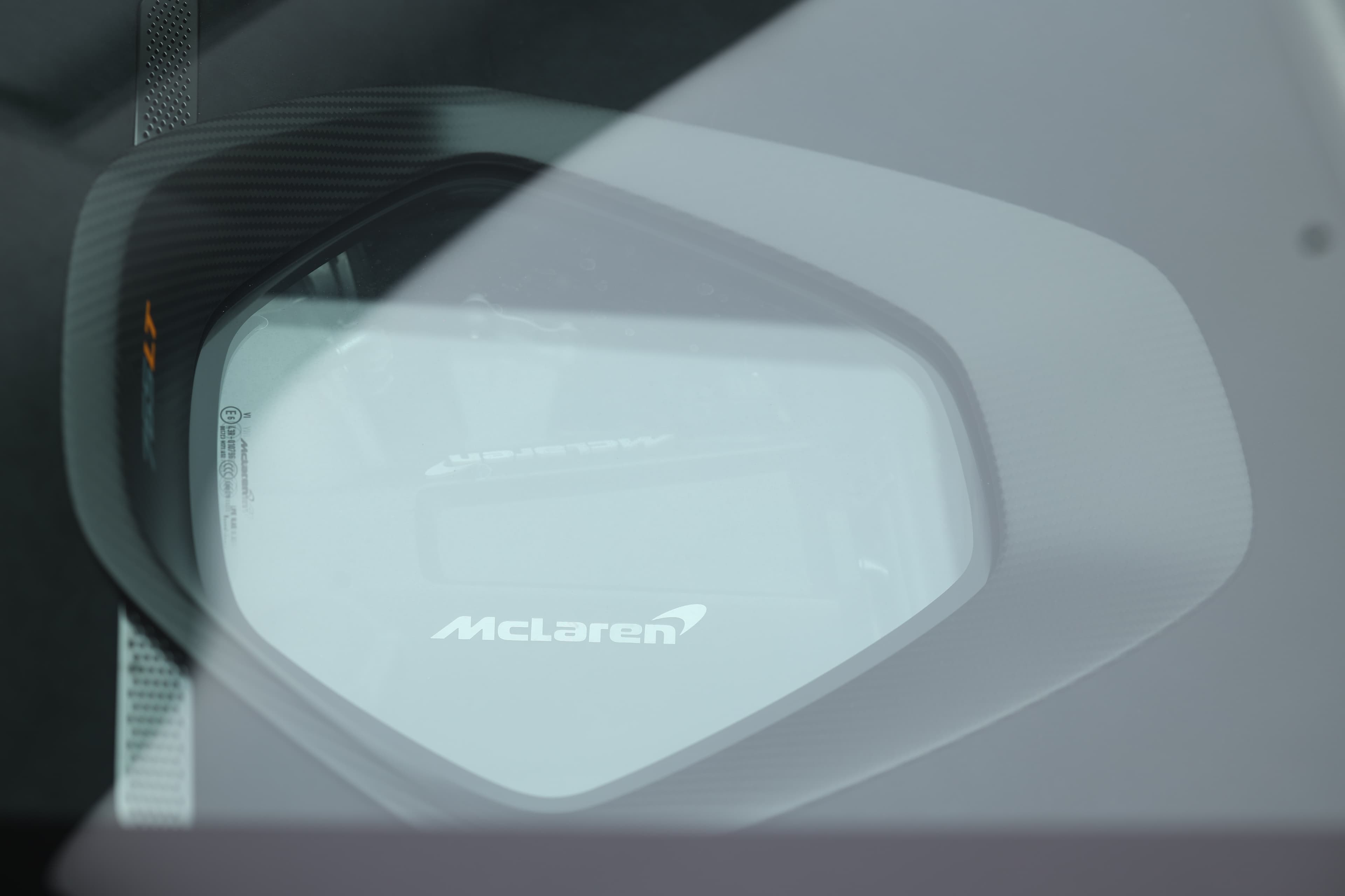 Gros plan sur le moteur de la McLaren 765LT, mettant en avant la vue à travers le capot en verre, soulignant la puissance et la technologie avancée qui se cachent sous son design épuré.