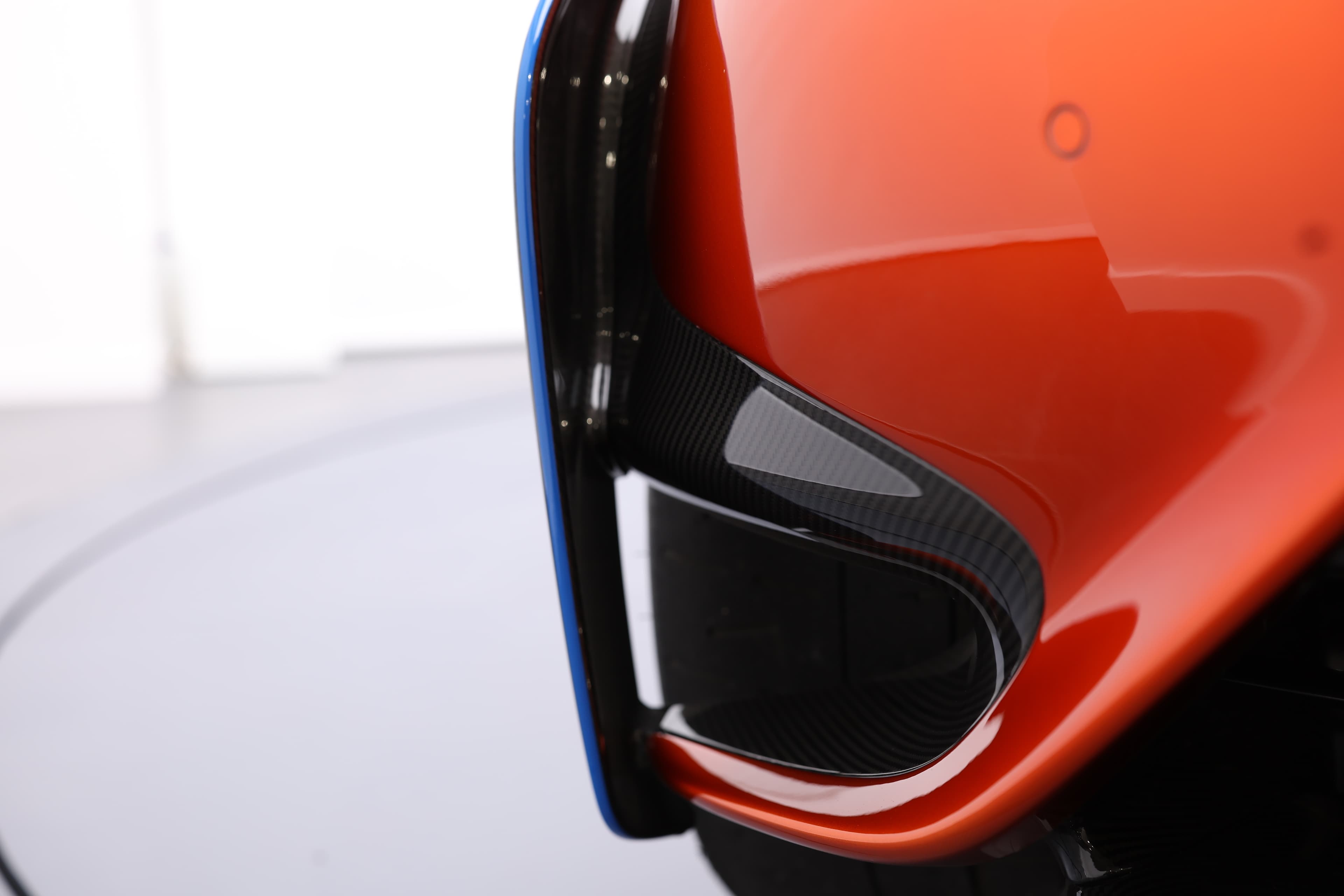 Gros plan sur le détail du diffuseur arrière de la McLaren 765LT, mettant en avant la combinaison de la finition en carbone et des éléments de design distinctifs, accentuant l'aérodynamisme et l'esthétique de la voiture.