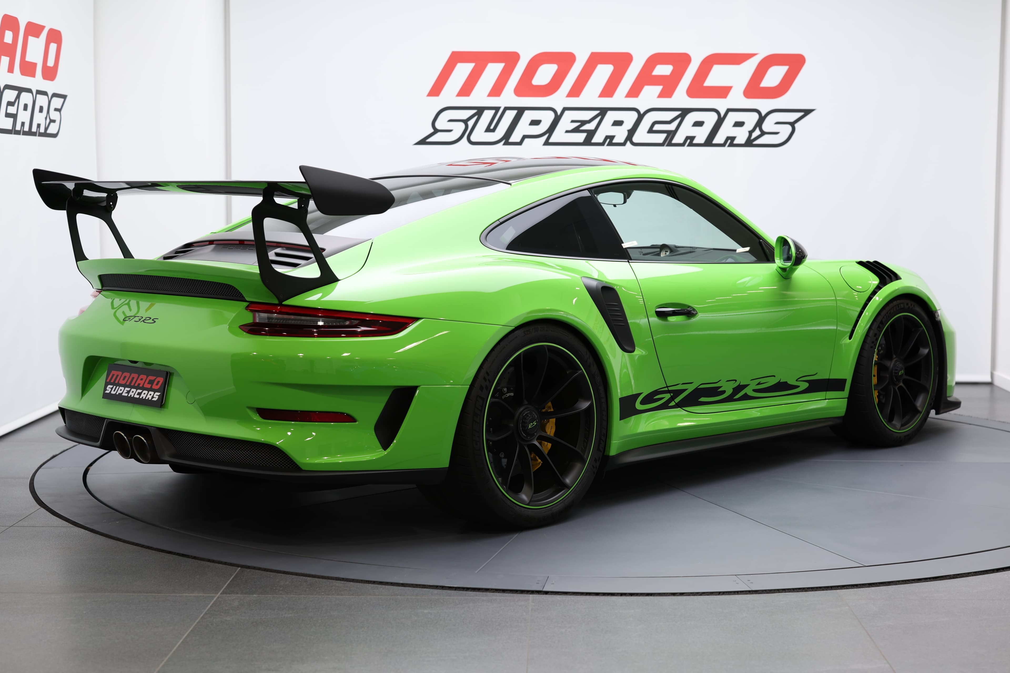 Porsche 911 GT3 RS 991 verte, vue arrière trois-quarts, équipée d’un aileron arrière carbone emblématique, d’un châssis affûté et d’un design radical dédié à la performance sur route et sur circuit.