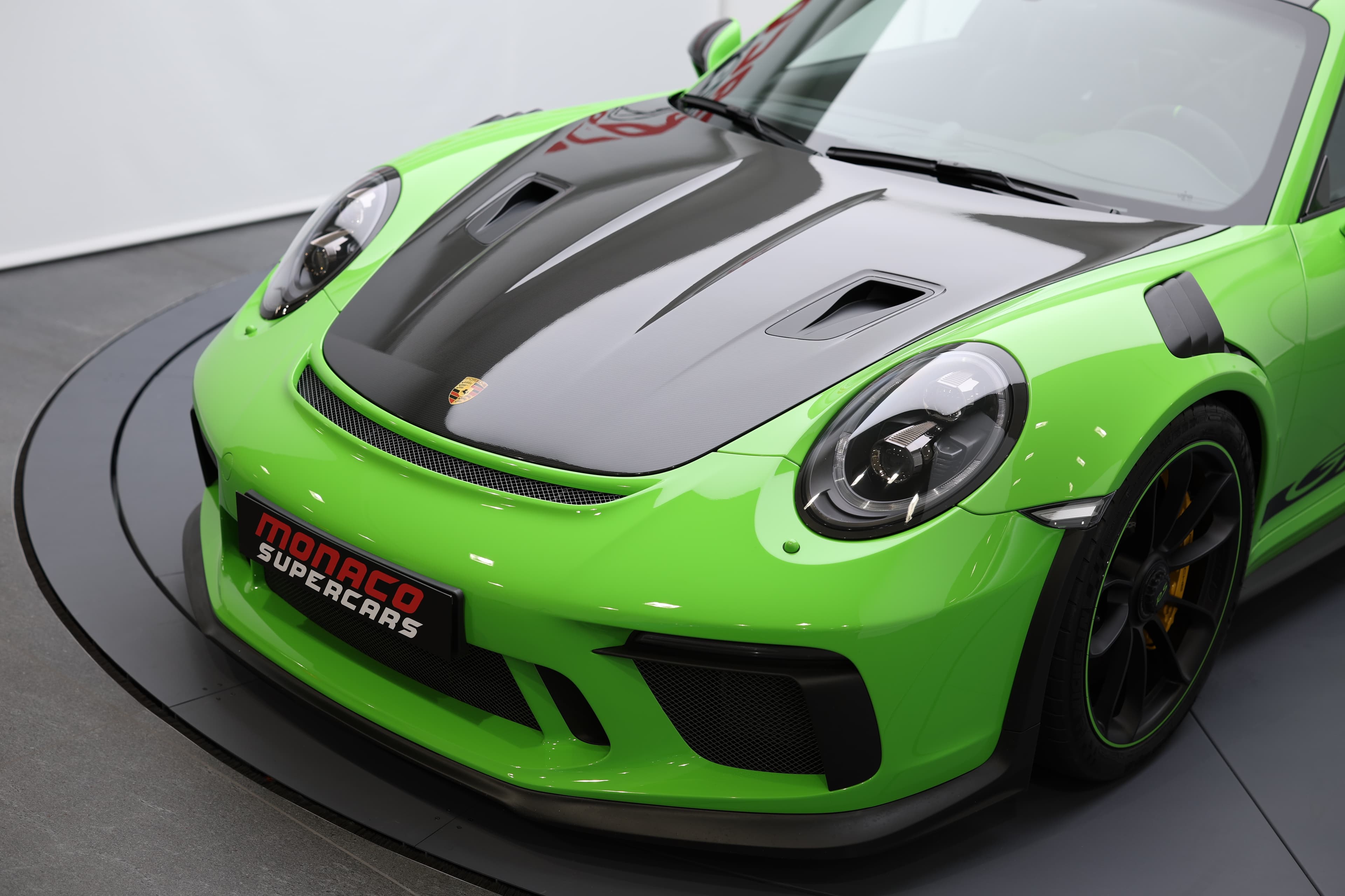 Détail de la Porsche 911 GT3 RS 991 verte mettant en avant le capot en carbone apparent et le pare-brise profilé, soulignant son aérodynamisme et son ADN 100 % performance.