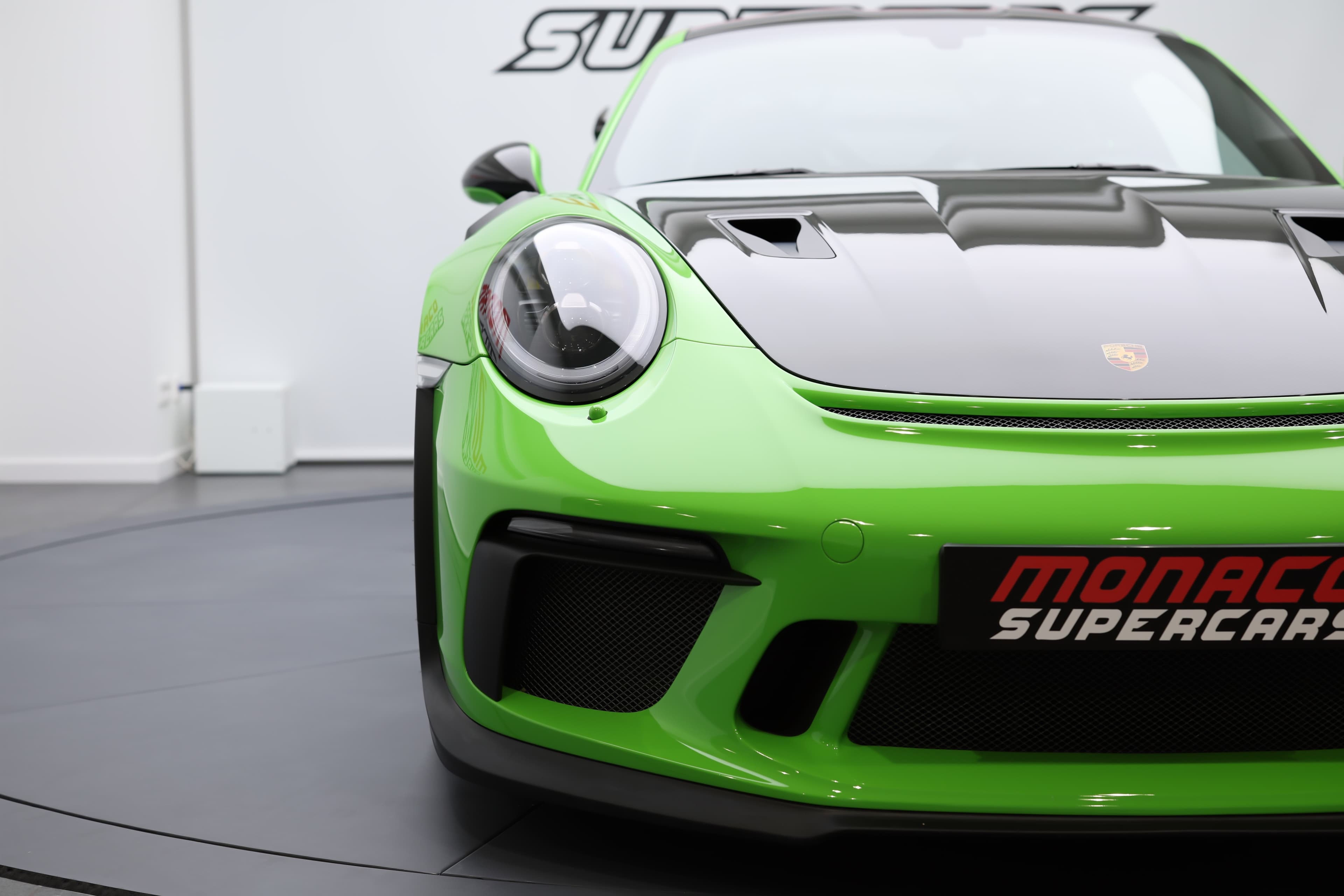 Vue avant de la Porsche 911 GT3 RS 991 verte mettant en avant son capot carbone, ses larges prises d’air et son design agressif conçu pour une efficacité maximale sur circuit.