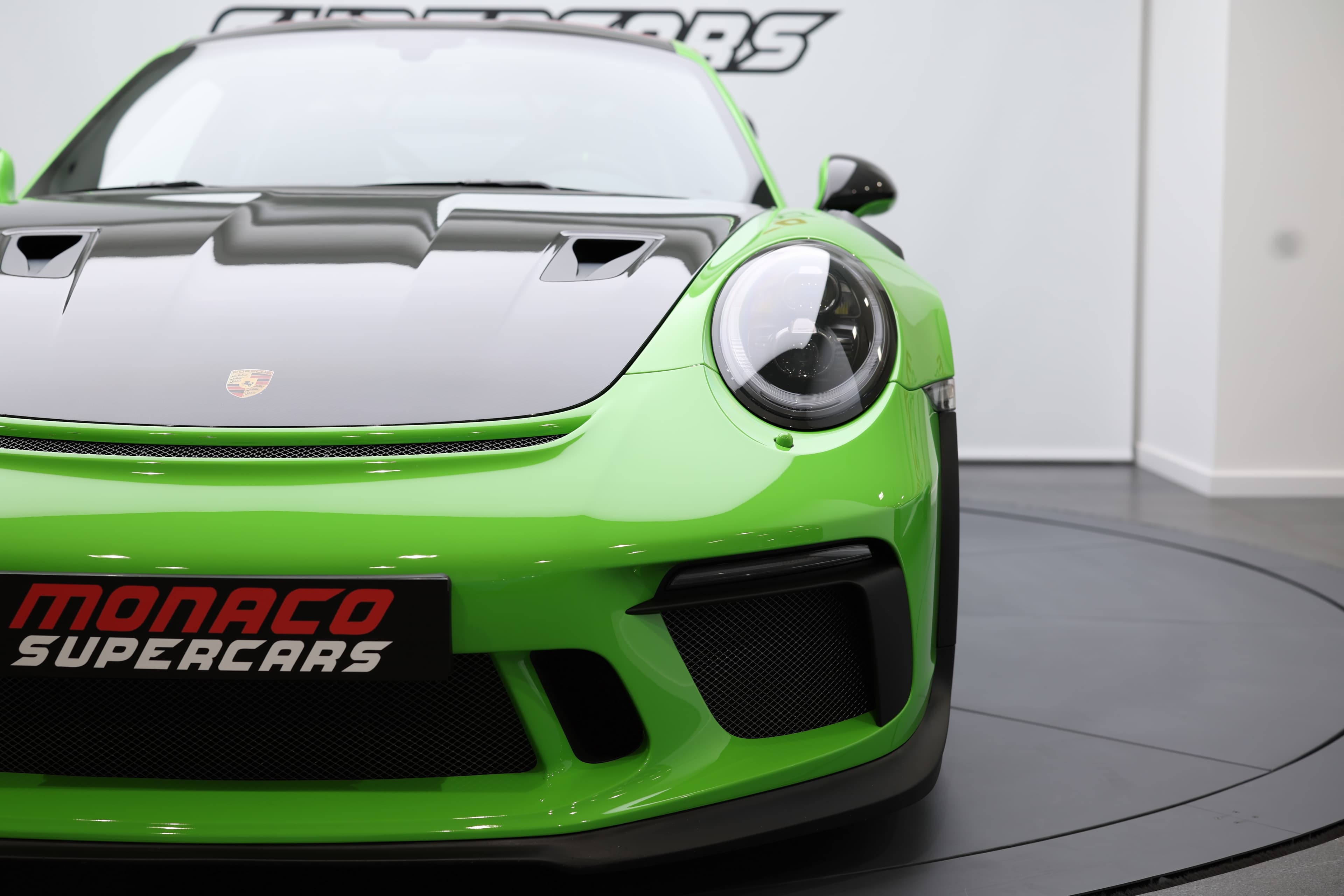 Vue avant de la Porsche 911 GT3 RS 991 verte mettant en avant son capot carbone, ses larges prises d’air et son design agressif conçu pour une efficacité maximale sur circuit.