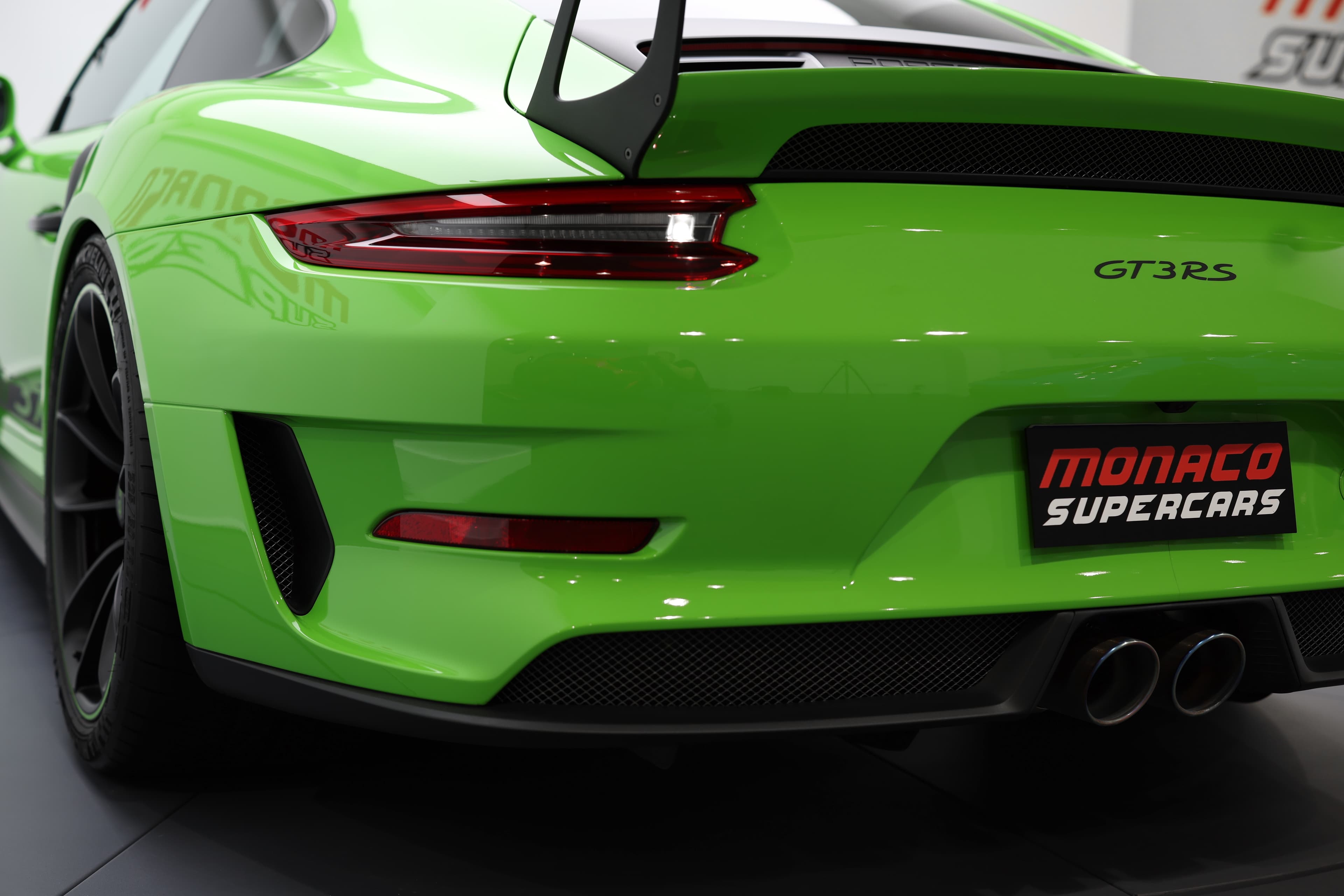 Vue arrière de la Porsche 911 GT3 RS (991) verte, soulignant le large diffuseur, les sorties d’échappement centrales, les feux arrière affinés et l’aileron fixe imposant, avec l’inscription GT3 RS confirmant son ADN radical orienté piste.