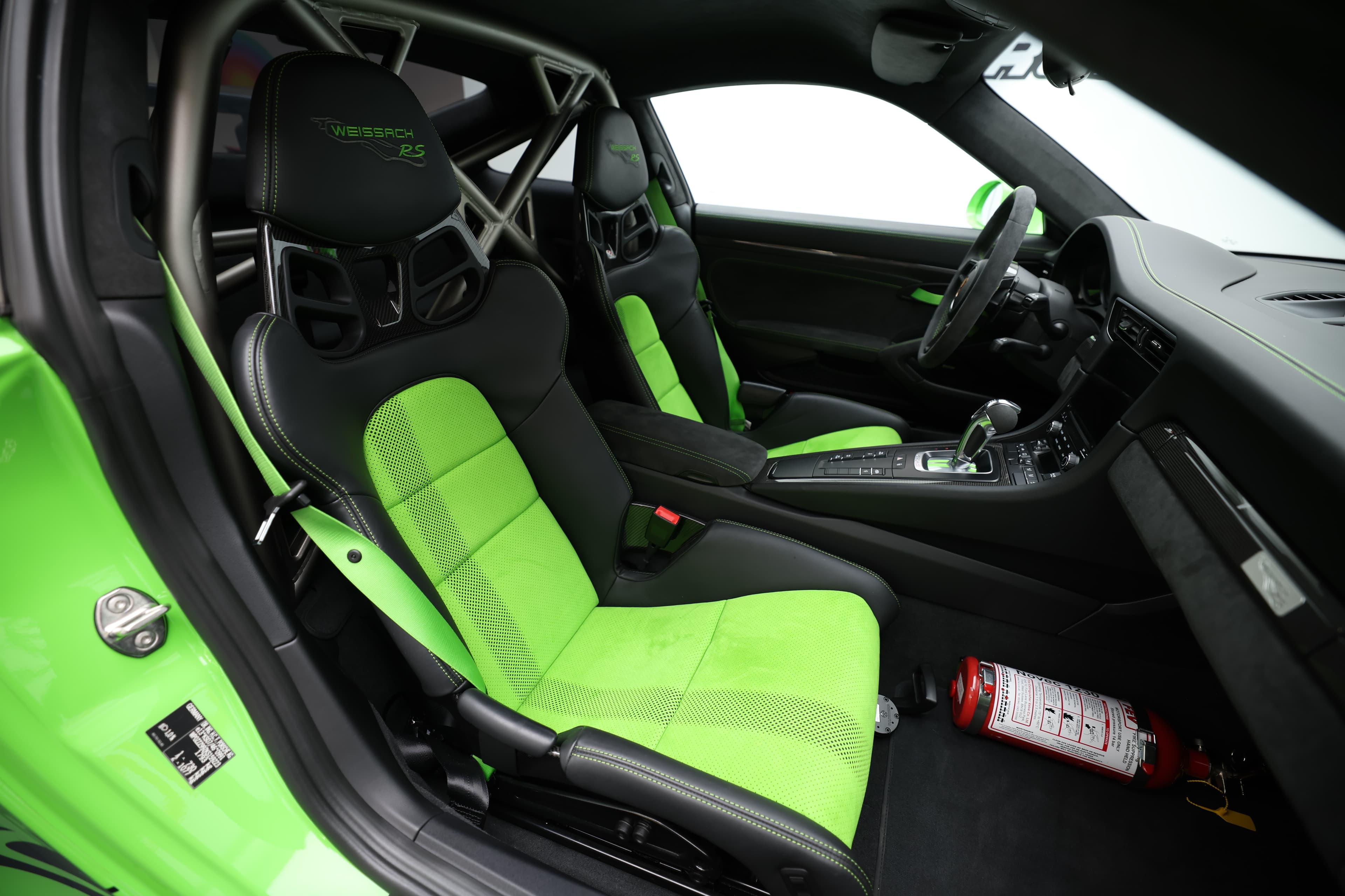 L'intérieur de la Porsche GT3 RS, avec ses sièges baquets en carbone et ses accents verts, allie confort et sportivité, créant une ambiance de course qui ravira les passionnés de performance.