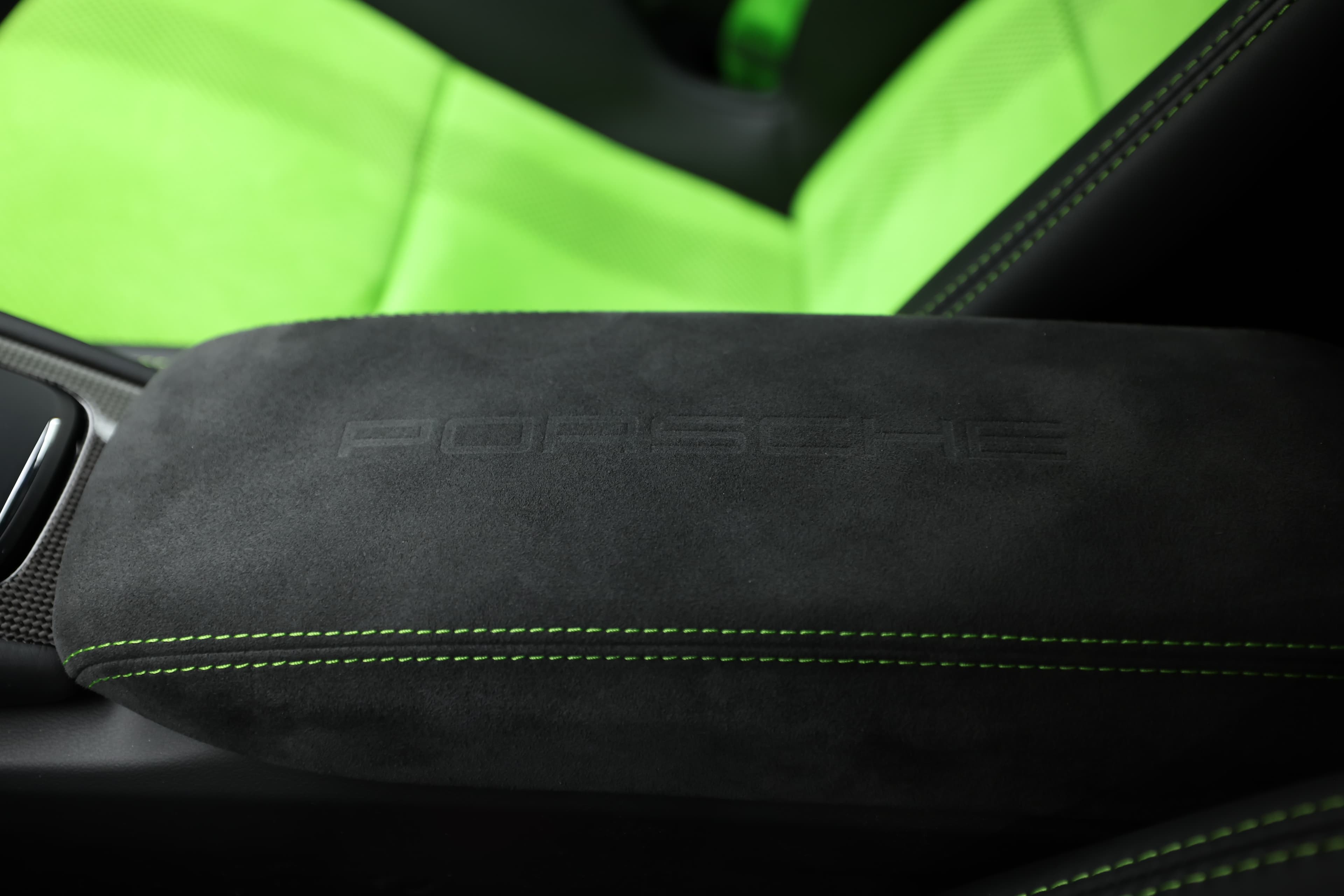 L'accoudoir de la Porsche GT3 RS, recouvert d'Alcantara et portant le logo Porsche, ajoute une touche de raffinement à l'intérieur. Les coutures contrastantes en vert soulignent l'attention portée aux détails et le caractère sportif de l'habitacle.