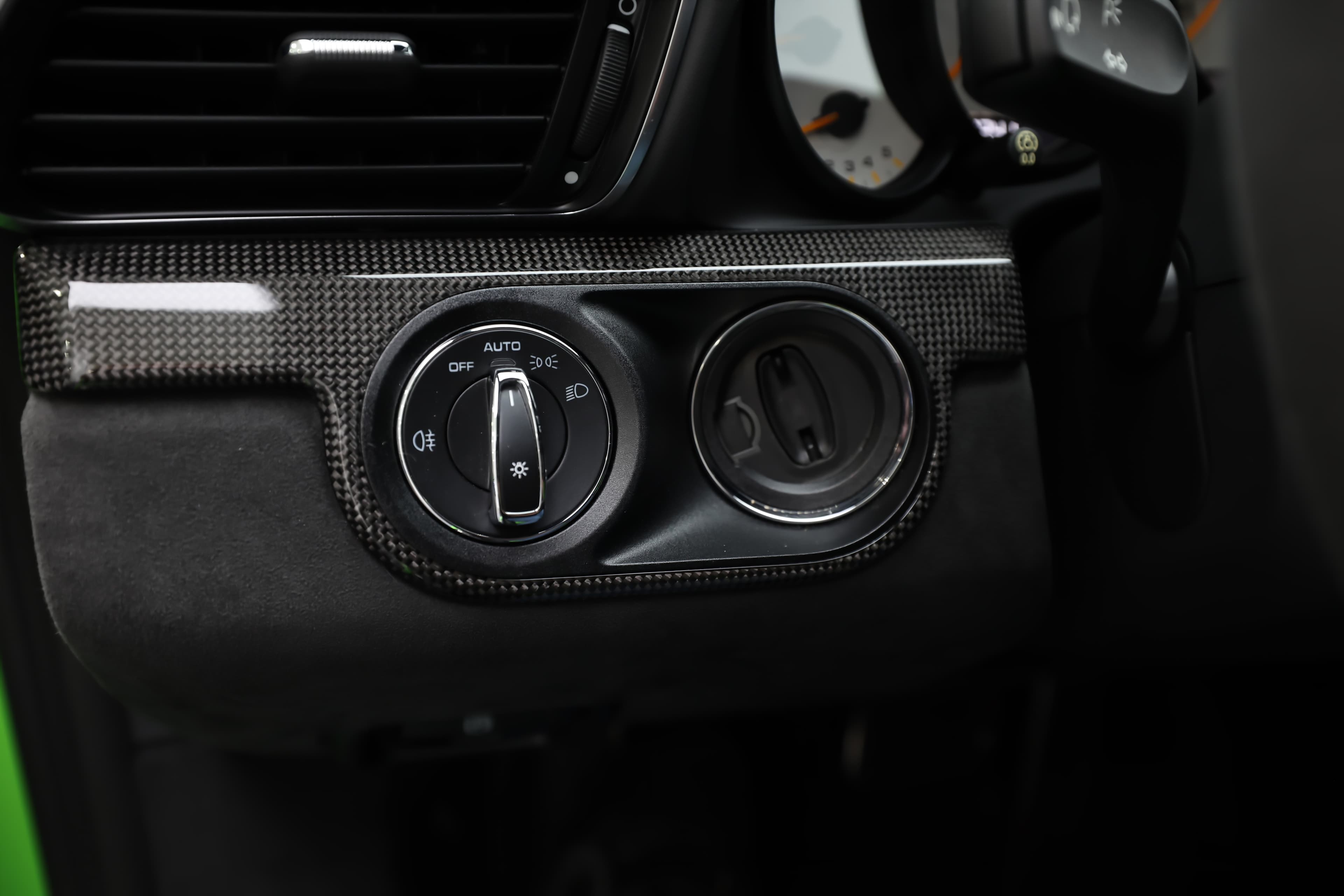 Les commandes d'éclairage et de gestion des aérateurs sur la Porsche GT3 RS sont intégrées de manière harmonieuse dans le design intérieur. Leur finition en carbone ajoute une touche sportive, tandis que leur ergonomie facilite l'accès et l'utilisation en conduite dynamique.