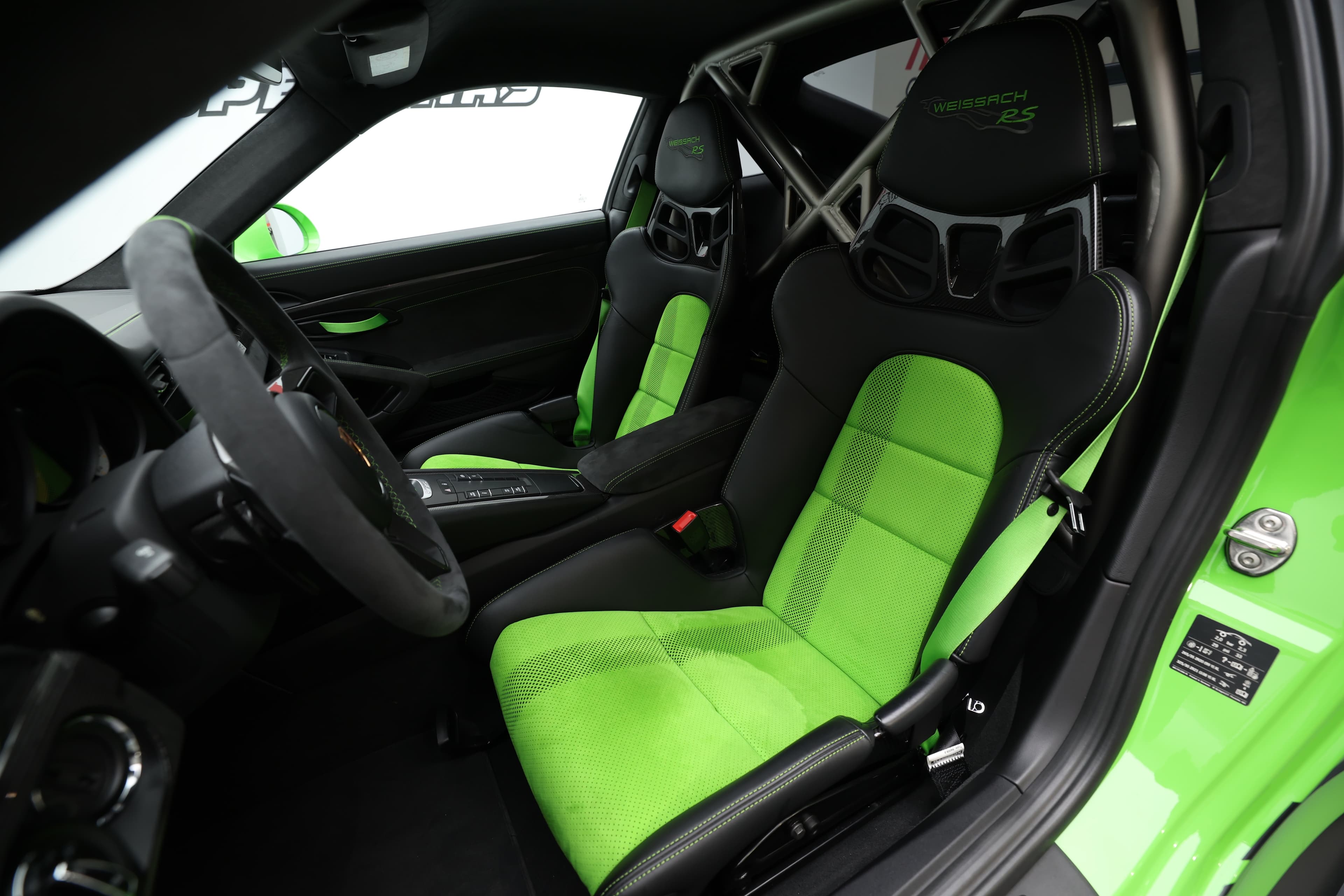 Les sièges baquets de la Porsche GT3 RS, ornés du logo "Weissach RS" et de surpiqûres vertes, offrent un mélange parfait de confort et de soutien, tout en célébrant l'héritage de performance de la marque.