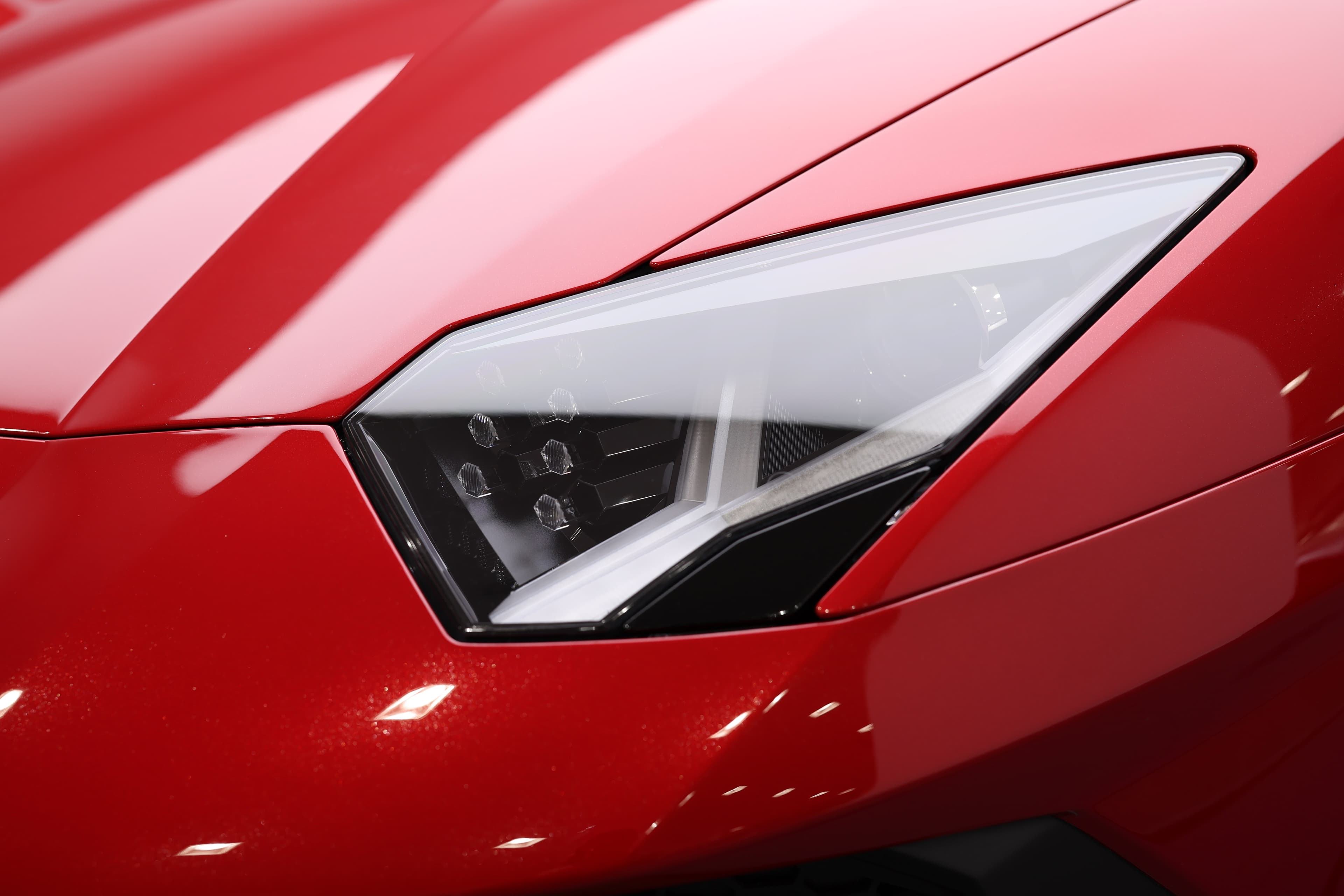 Admirez les feux avant emblématiques de la Lamborghini Aventador SV, fusion parfaite entre esthétique et technologie, offrant une visibilité exceptionnelle tout en accentuant son allure agressive.