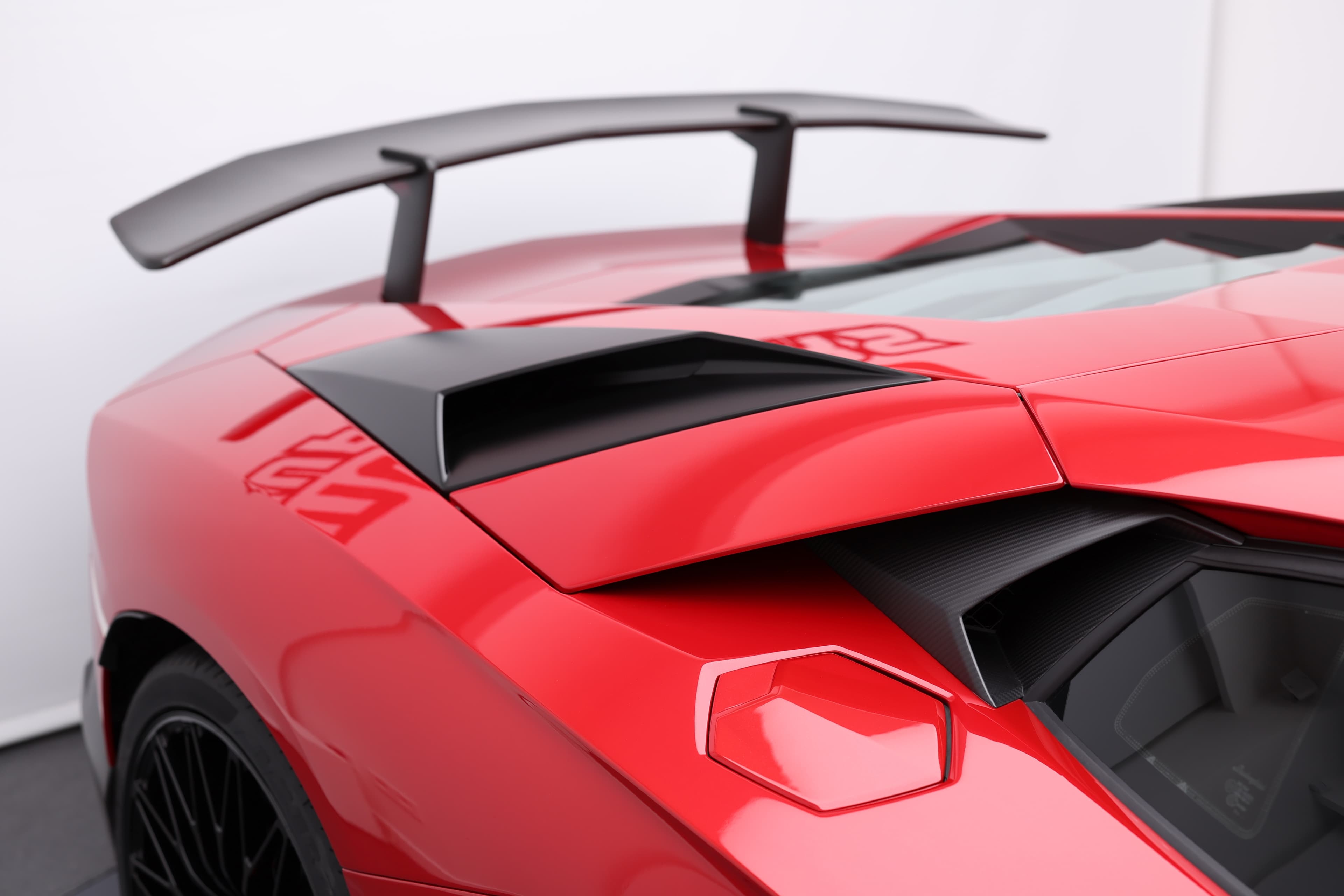 Regardez l'aileron arrière de la Lamborghini Aventador SV sous un nouvel angle, soulignant sa conception fonctionnelle qui améliore l'appui et la stabilité à grande vitesse, tout en ajoutant une touche d'agressivité au look de la voiture.
